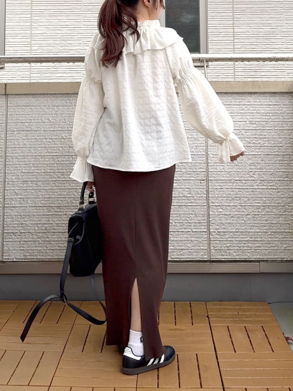 ホワイト系のシャツ/ブラウス、ブラウン系のスカート、ブラック系のハンドバッグを着用したレディースの春コーディネートの3枚目の写真