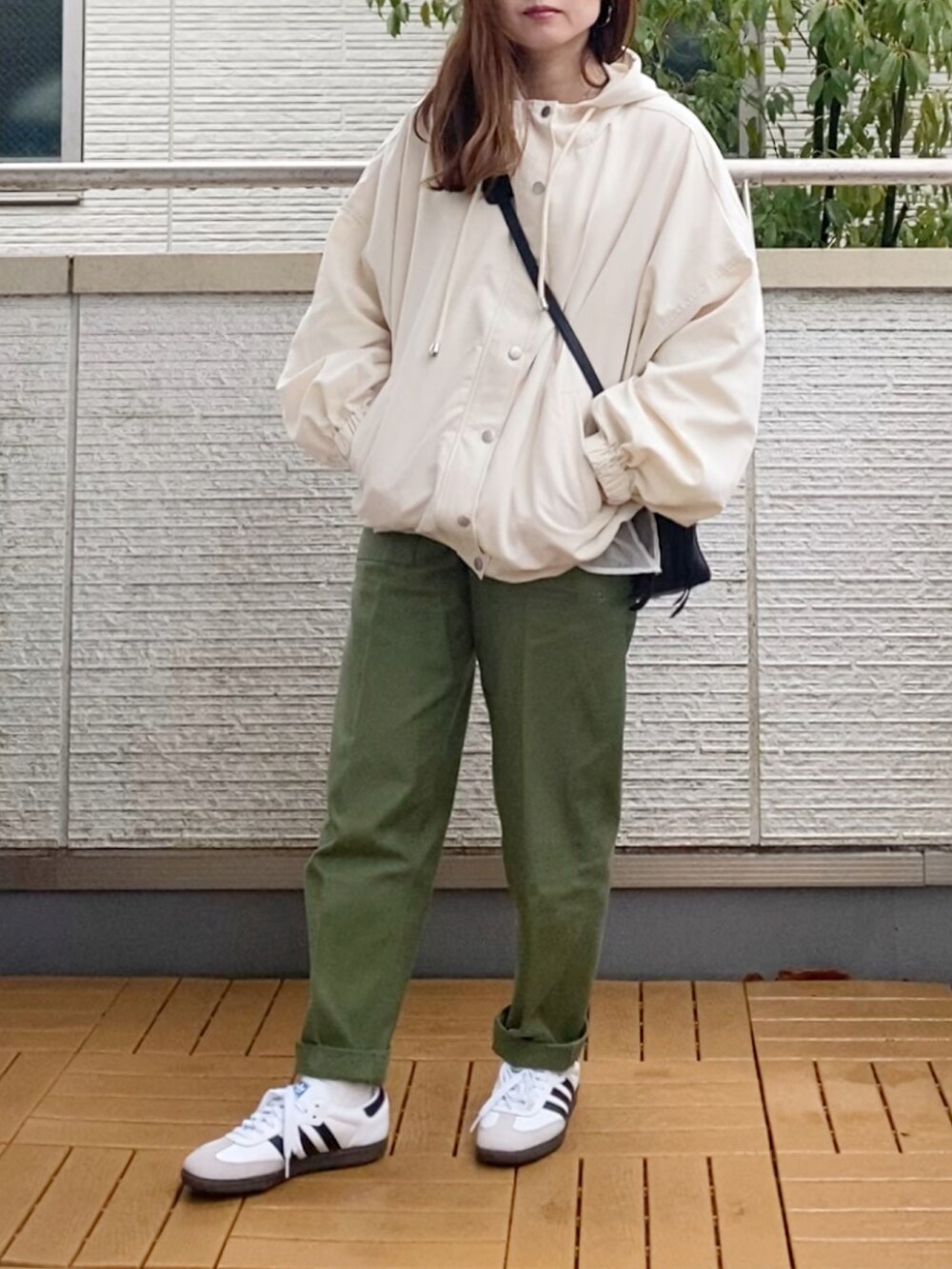 ホワイト系のマウンテンパーカー、ホワイト系のスウェット、グリーン系のその他パンツを着用したレディースの春コーディネートの5枚目の写真