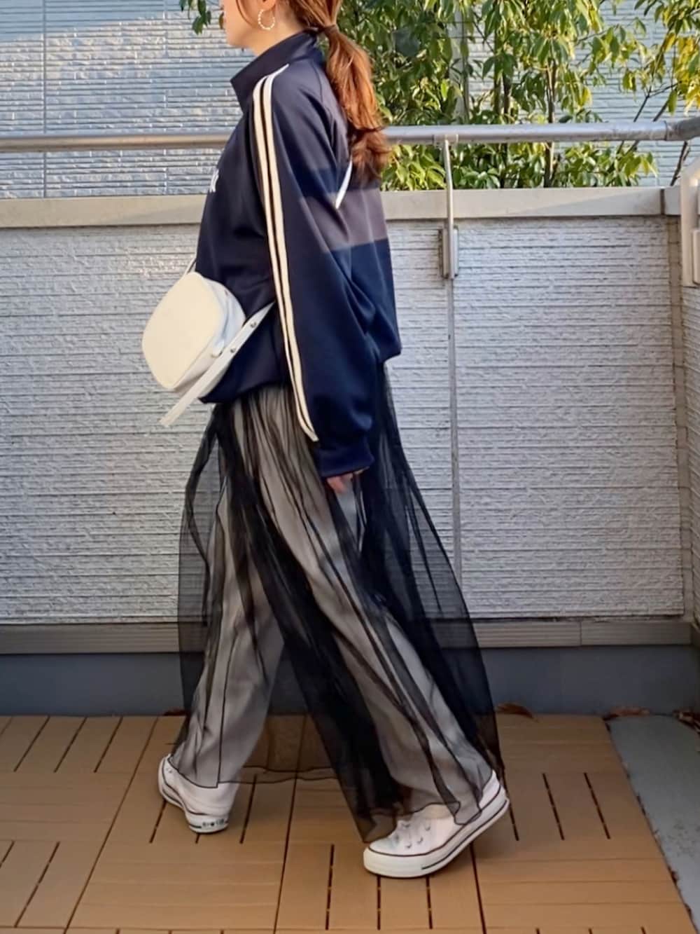 ブルー系のジャージ、ベージュ系のその他パンツ、ブラック系のワンピースを着用したレディースの春コーディネートの3枚目の写真