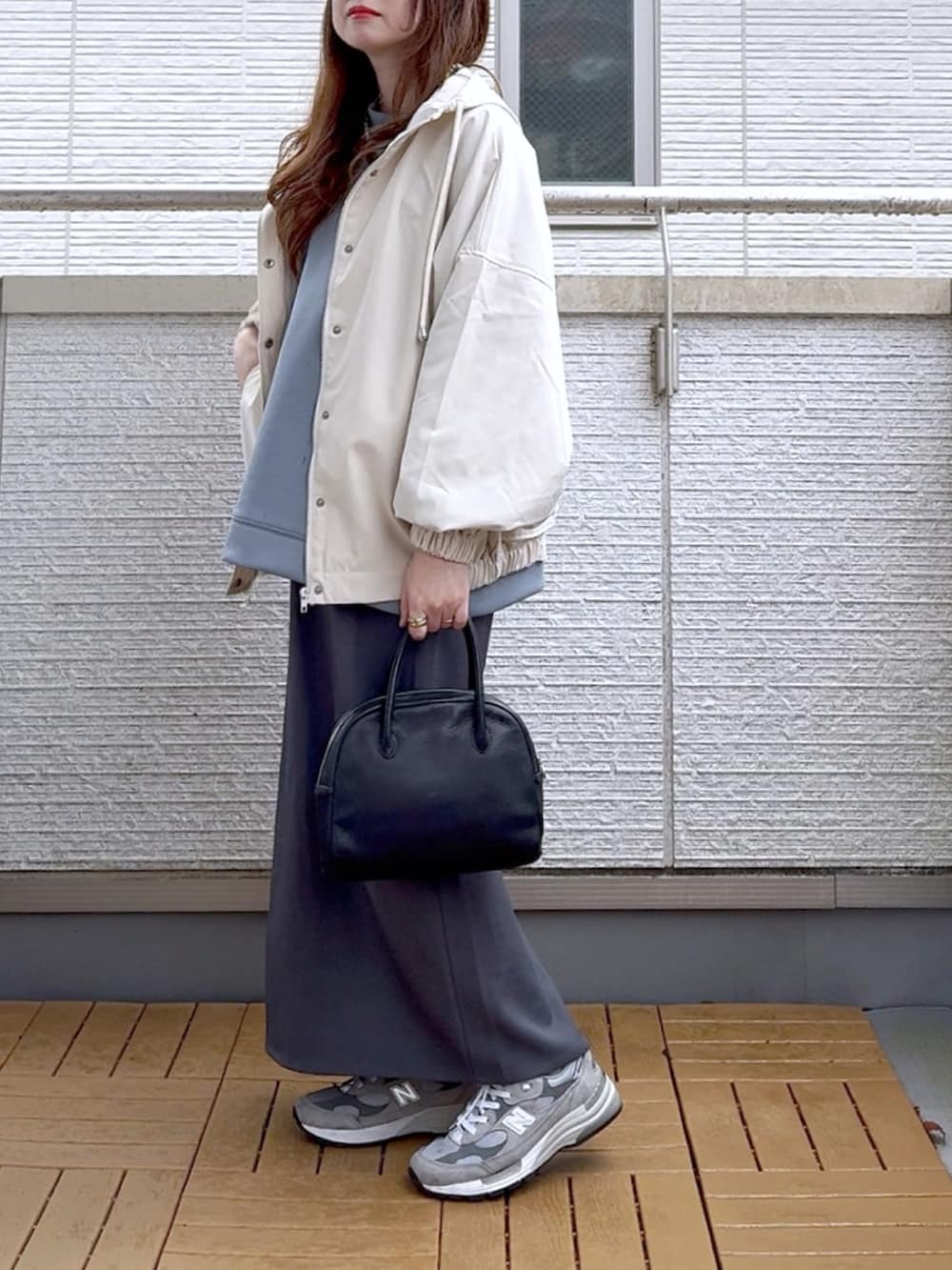 ホワイト系のマウンテンパーカー、ブルー系のスウェット、グレー系のスカートを着用したレディースの春コーディネートの3枚目の写真