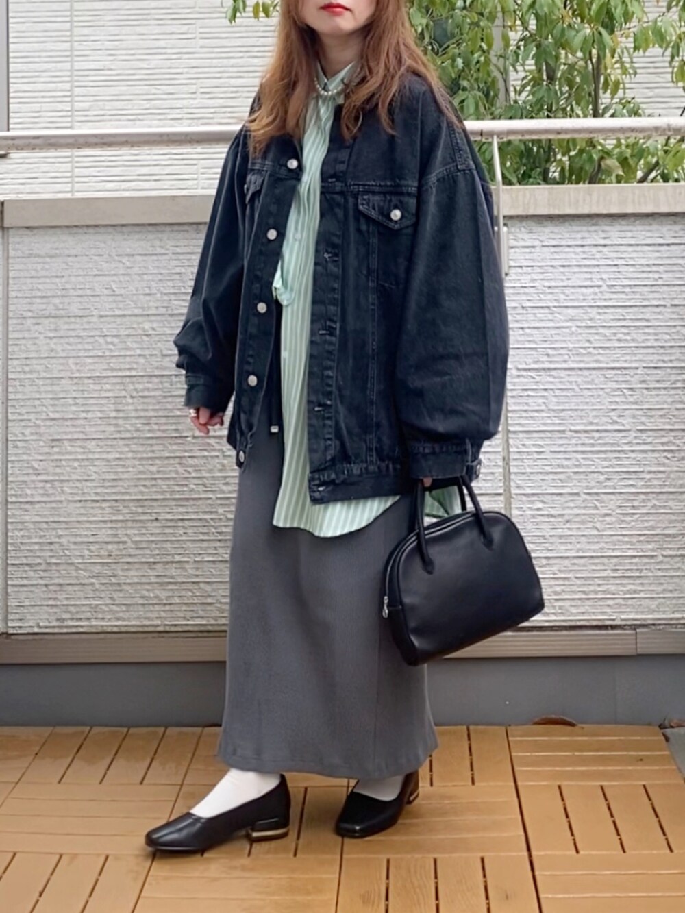 ブラック系のデニムジャケット、グリーン系のシャツ/ブラウス、グレー系のスカートを着用したレディースの春コーディネートの4枚目の写真