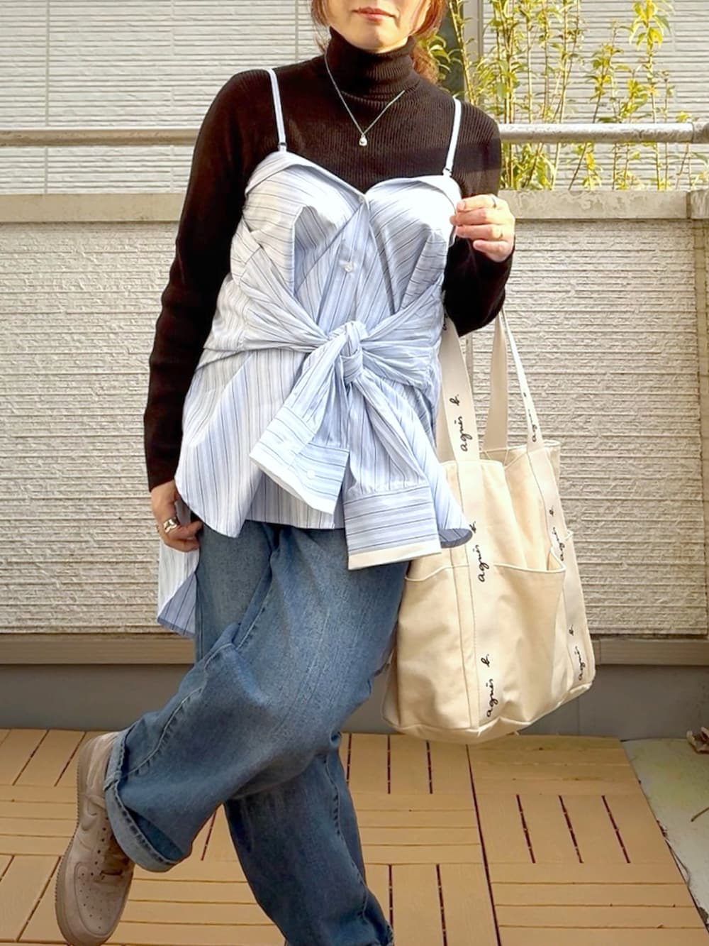 ブルー系のシャツ/ブラウス、ブルー系のデニムパンツ、ブラウン系のスニーカーを着用したレディースの冬コーディネートの4枚目の写真