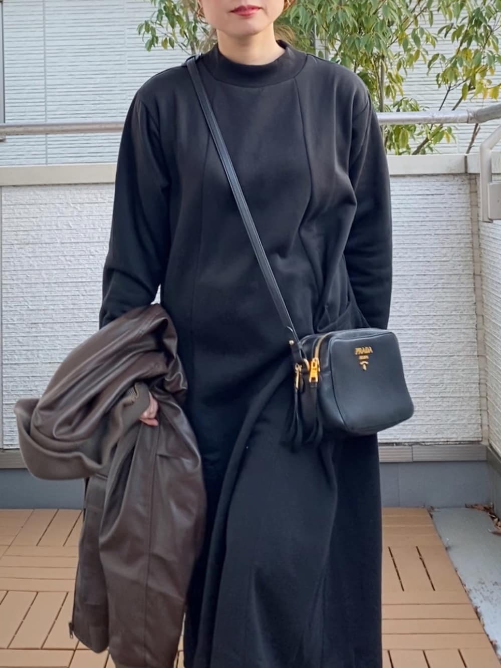 ブラック系のワンピース、ブラウン系のライダースジャケット、ブラック系のブーツを着用したレディースの冬コーディネートの5枚目の写真