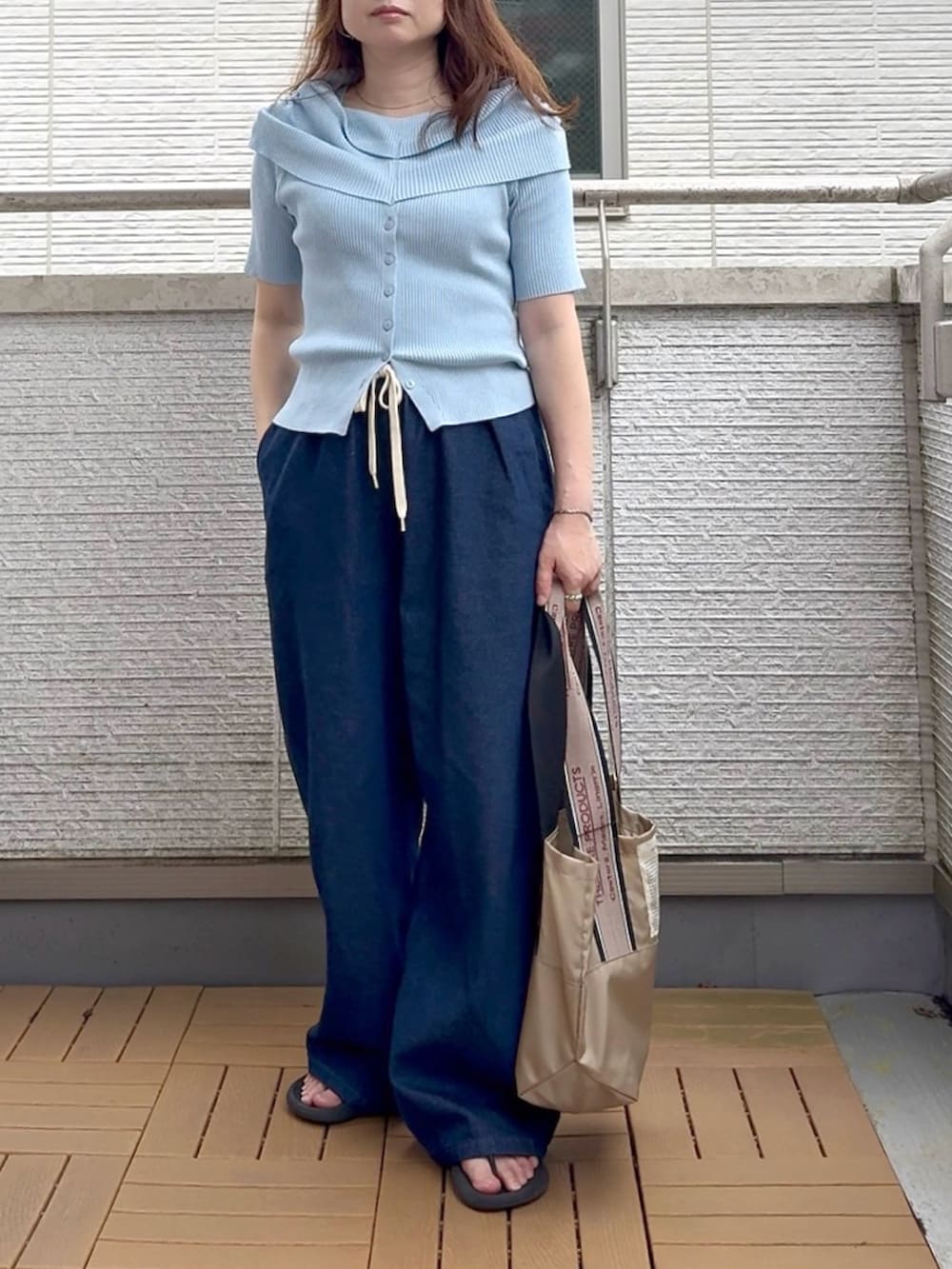 ブルー系のニット/セーター、ブルー系のデニムパンツを着用したレディースの夏コーディネートの2枚目の写真