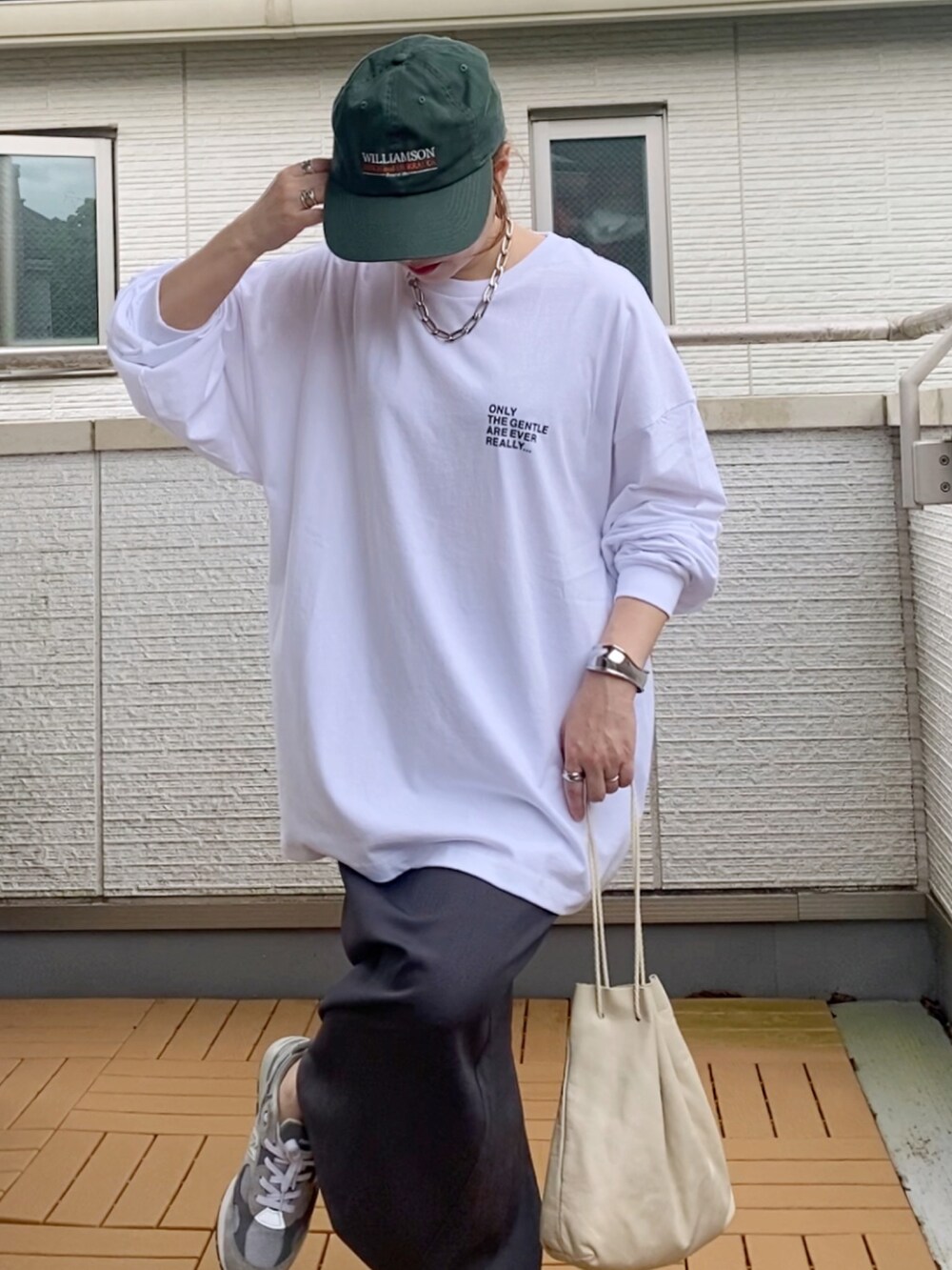 ホワイト系のTシャツ/カットソー、グレー系のスカート、グレー系のスニーカーを着用したレディースの秋コーディネートの4枚目の写真