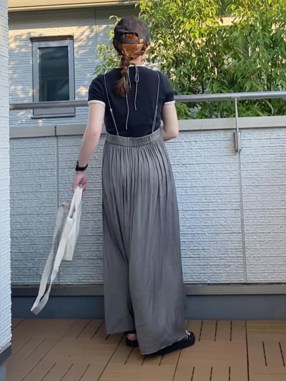 ブラック系のTシャツ/カットソー、グリーン系のスカート、ホワイト系のトートバッグを着用したレディースの夏コーディネートの3枚目の写真