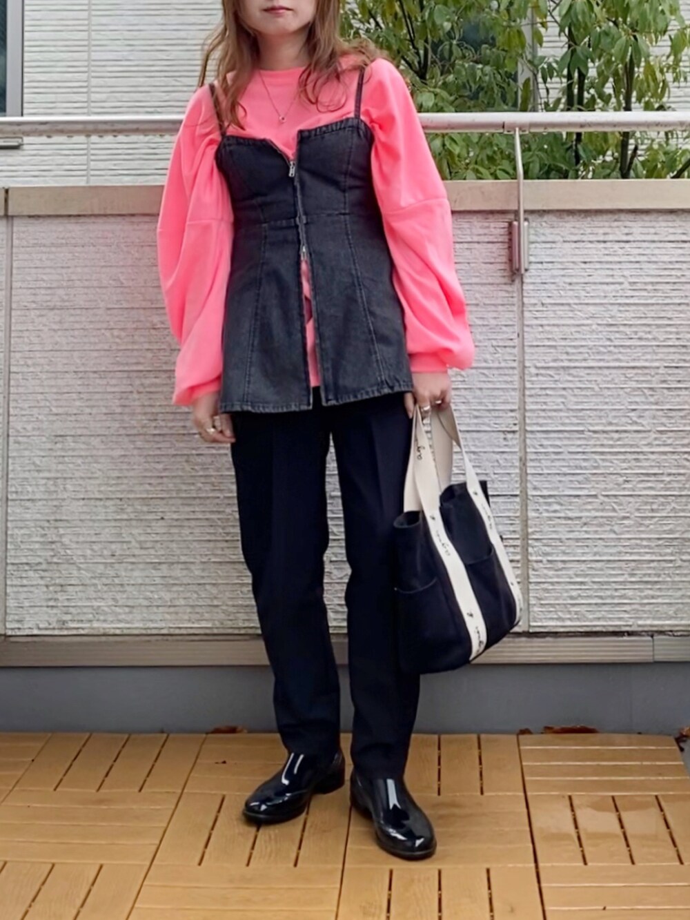 ピンク系のTシャツ/カットソー、ブラック系のベスト、ブラック系のその他パンツを着用したレディースの春コーディネートの2枚目の写真