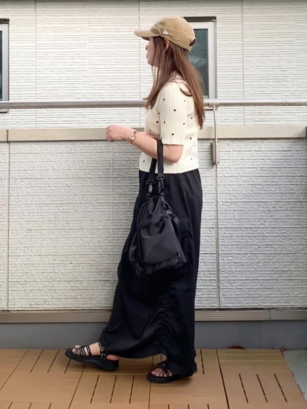 ホワイト系のニット/セーター、ブラック系のスカート、ブラック系のショルダーバッグを着用したレディースの夏コーディネートの2枚目の写真