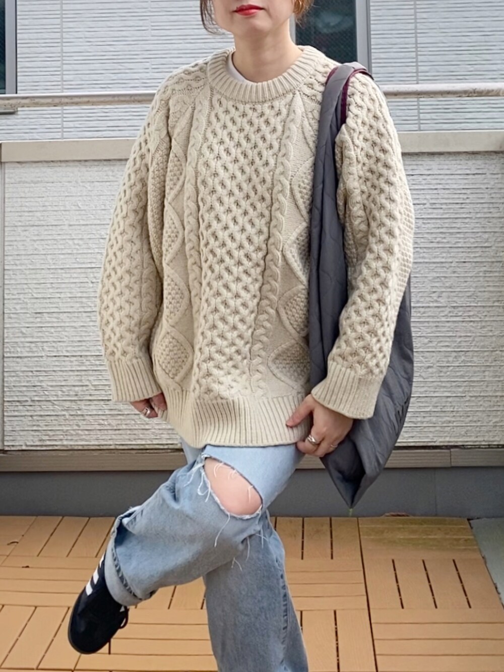 ホワイト系のニット/セーター、ブルー系のデニムパンツ、グレー系のトートバッグを着用したレディースの秋コーディネートの4枚目の写真