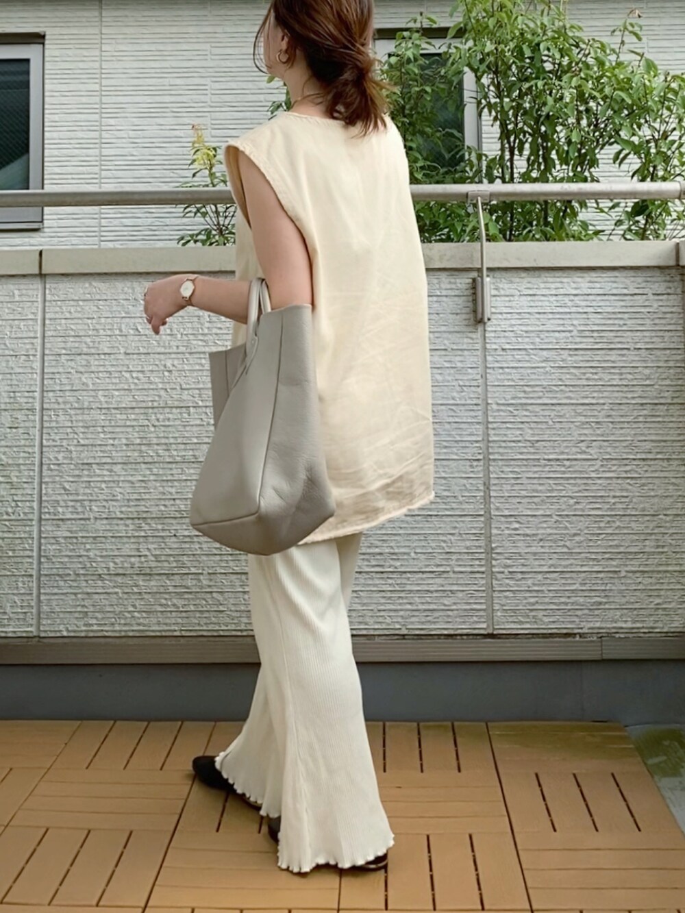 ホワイト系のベスト、ホワイト系のその他パンツ、ベージュ系のトートバッグを着用したレディースの夏コーディネートの2枚目の写真