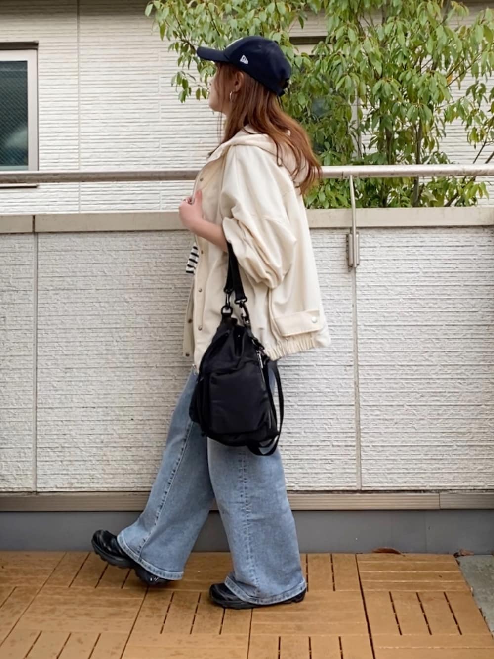 ホワイト系のマウンテンパーカー、ブラック系のTシャツ/カットソー、ブルー系のデニムパンツを着用したレディースの春コーディネートの3枚目の写真