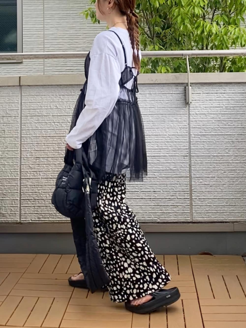 ブラック系のキャミソール、ブラック系のその他パンツ、ブラック系のショルダーバッグを着用したレディースの春コーディネートの2枚目の写真