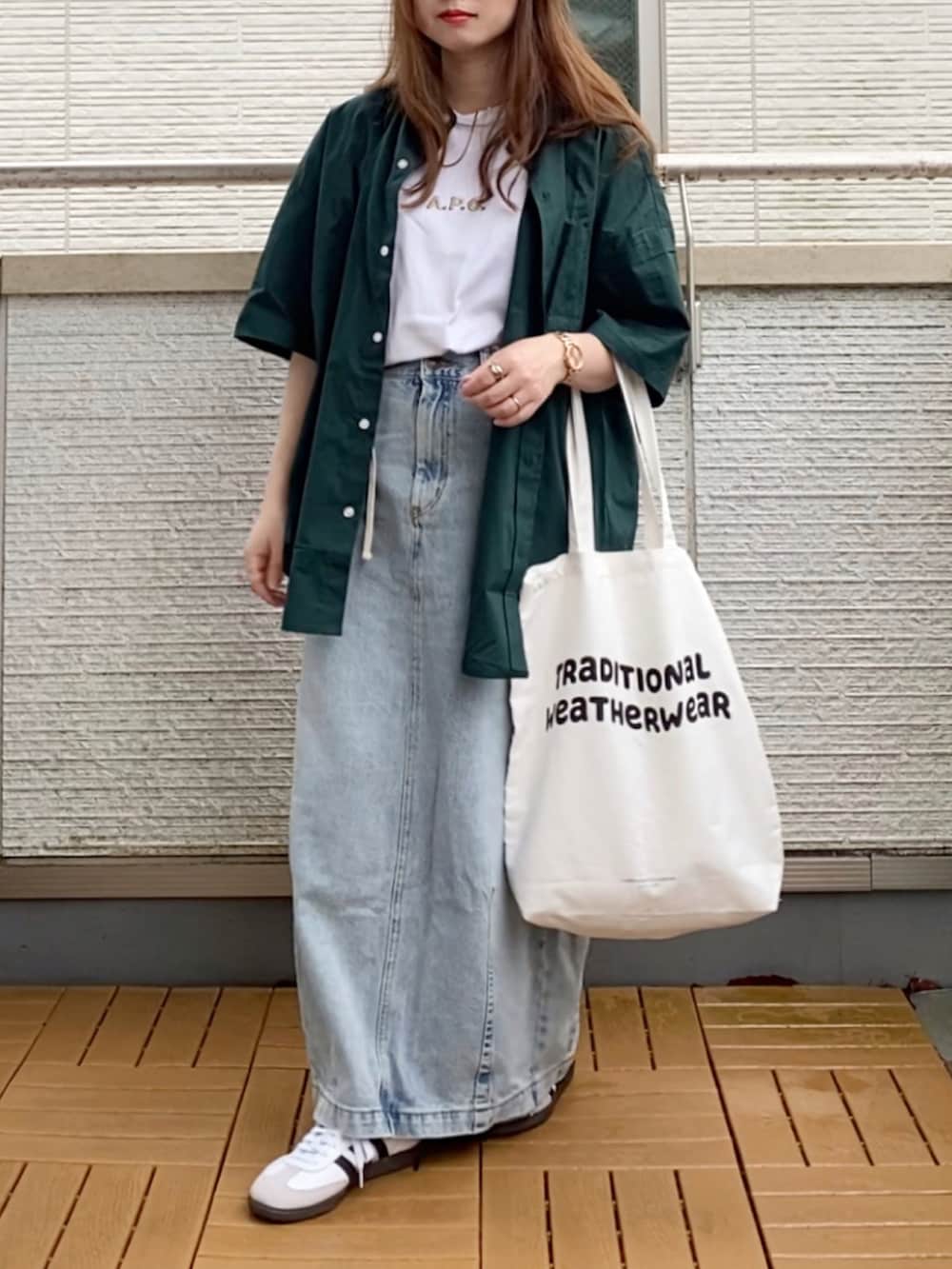 グリーン系のシャツ/ブラウス、イエロー系のTシャツ/カットソー、ブルー系のデニムスカートを着用したレディースの夏コーディネートの2枚目の写真