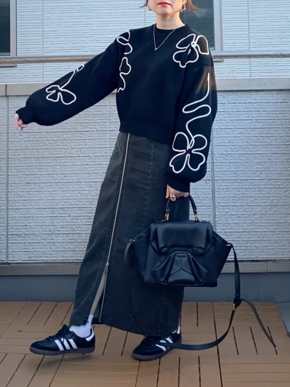 ブラック系のニット/セーター、ブラック系のブルゾン、ブラック系のスカートを着用したレディースの冬コーディネートの4枚目の写真