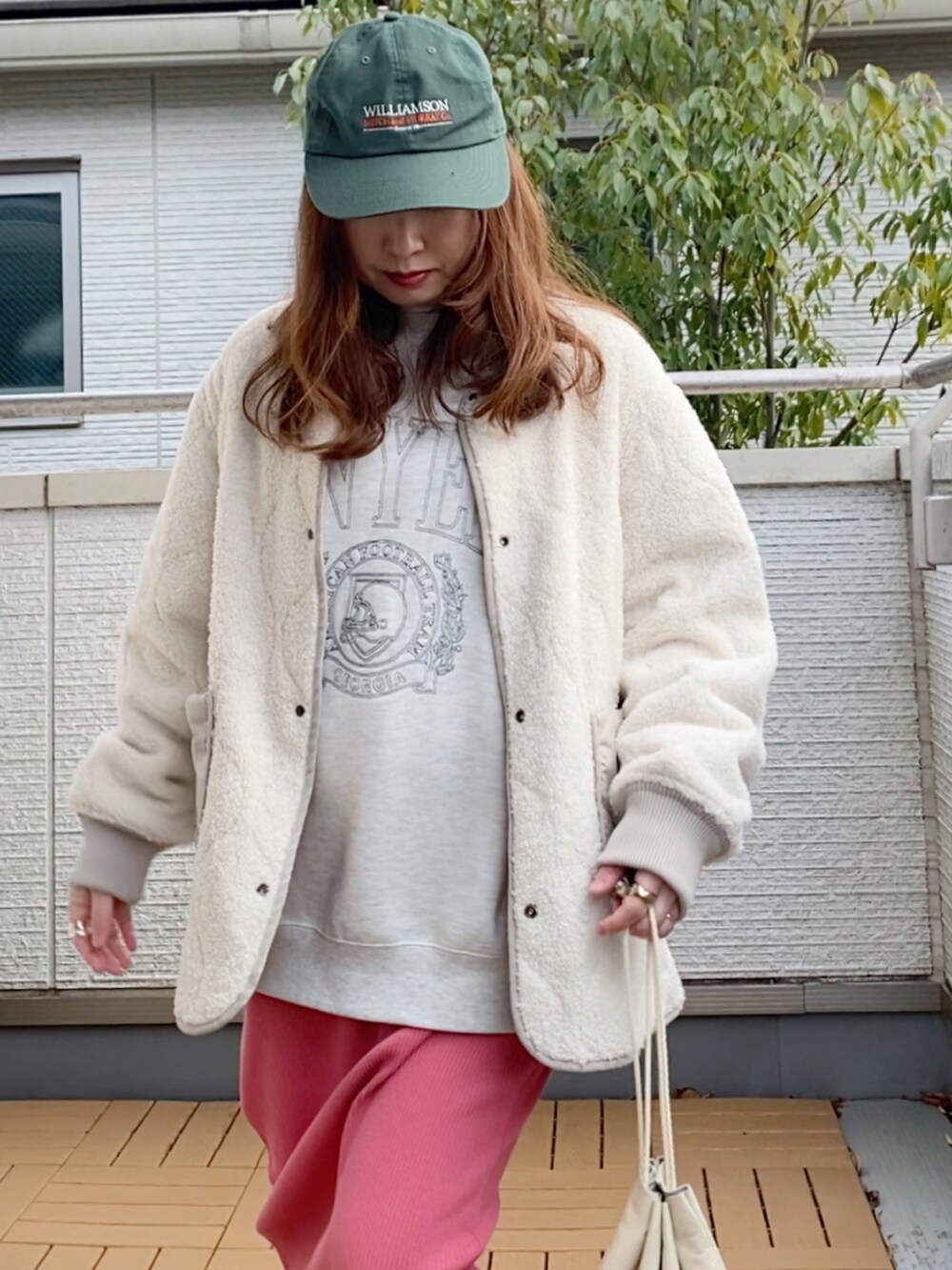 ベージュ系のブルゾン、グレー系のスウェット、ピンク系のスカートを着用したレディースの冬コーディネートの3枚目の写真