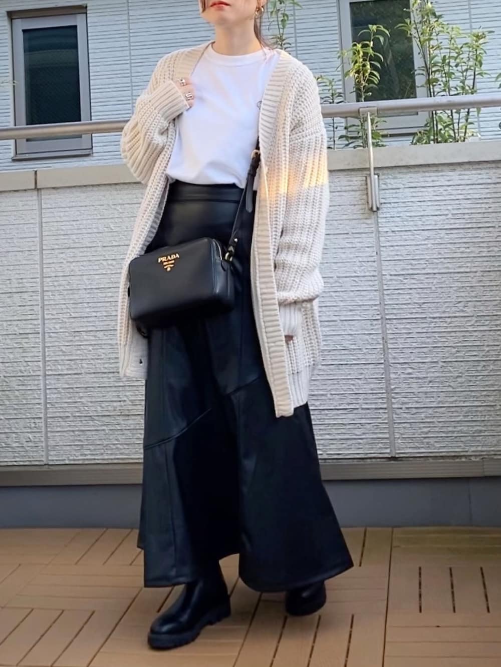 ホワイト系のTシャツ/カットソー、ホワイト系のカーディガン/ボレロ、ブラック系のスカートを着用したレディースの秋コーディネートの2枚目の写真
