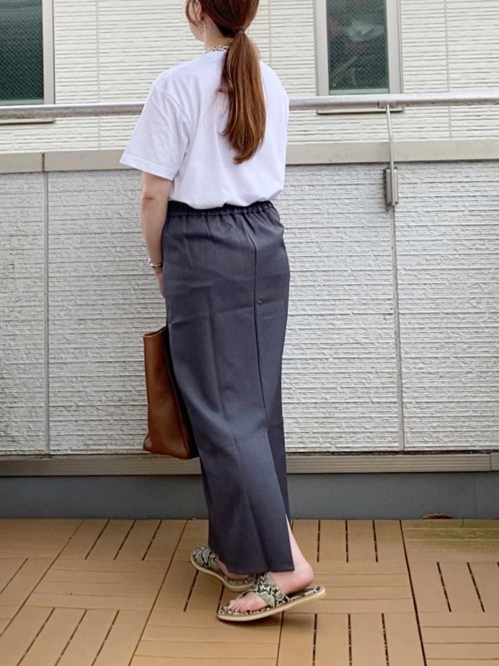 ホワイト系のTシャツ/カットソー、グレー系のスカート、ブラウン系のトートバッグを着用したレディースの夏コーディネートの3枚目の写真