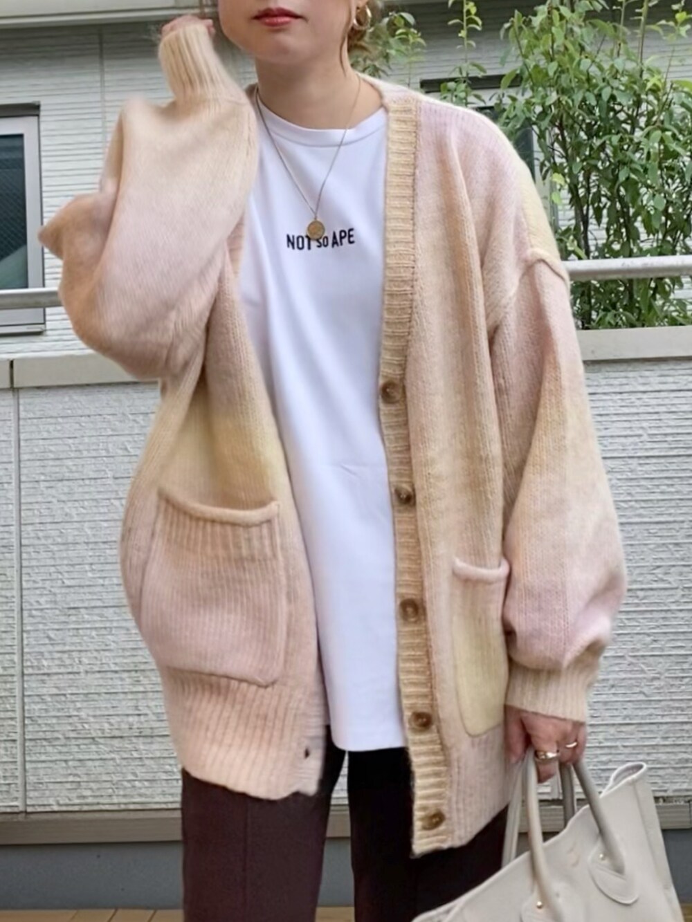 ピンク系のカーディガン/ボレロ、ホワイト系のTシャツ/カットソー、ブラウン系のその他パンツを着用したレディースの秋コーディネートの2枚目の写真