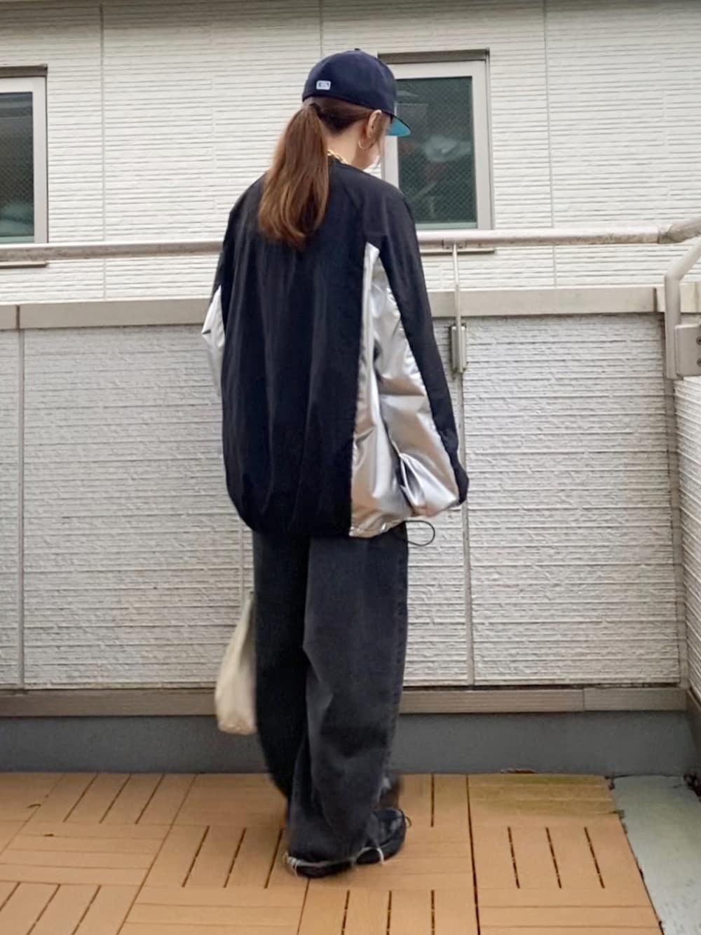 ブラック系のトップス、ブラック系のデニムパンツ、ブラック系のスニーカーを着用したレディースの秋コーディネートの3枚目の写真