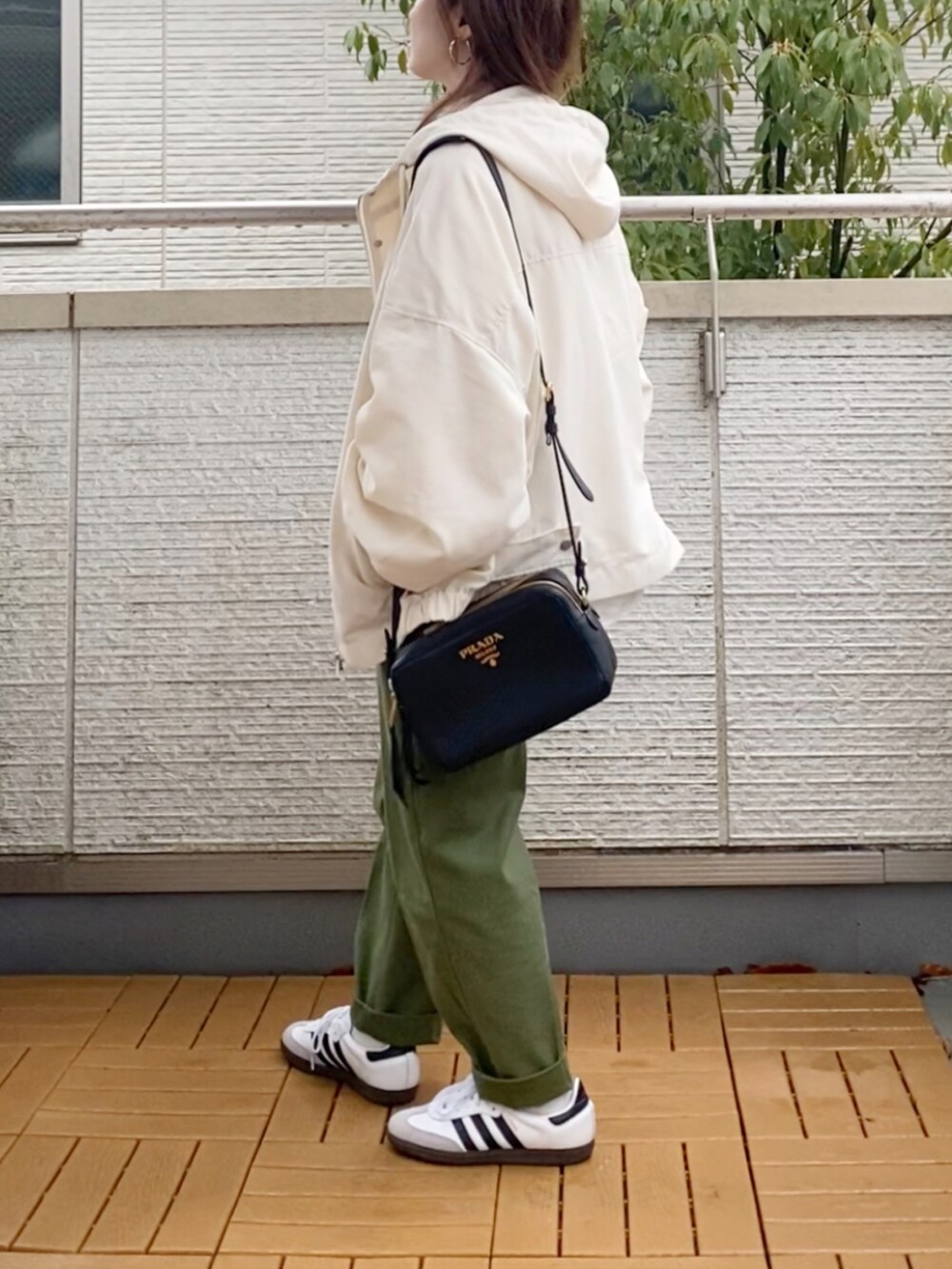 ホワイト系のマウンテンパーカー、ホワイト系のスウェット、グリーン系のその他パンツを着用したレディースの春コーディネートの4枚目の写真