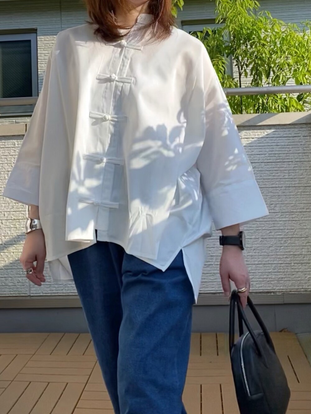 ホワイト系のシャツ/ブラウス、ブルー系のその他パンツ、ブラック系のショルダーバッグを着用したレディースの春コーディネートの2枚目の写真