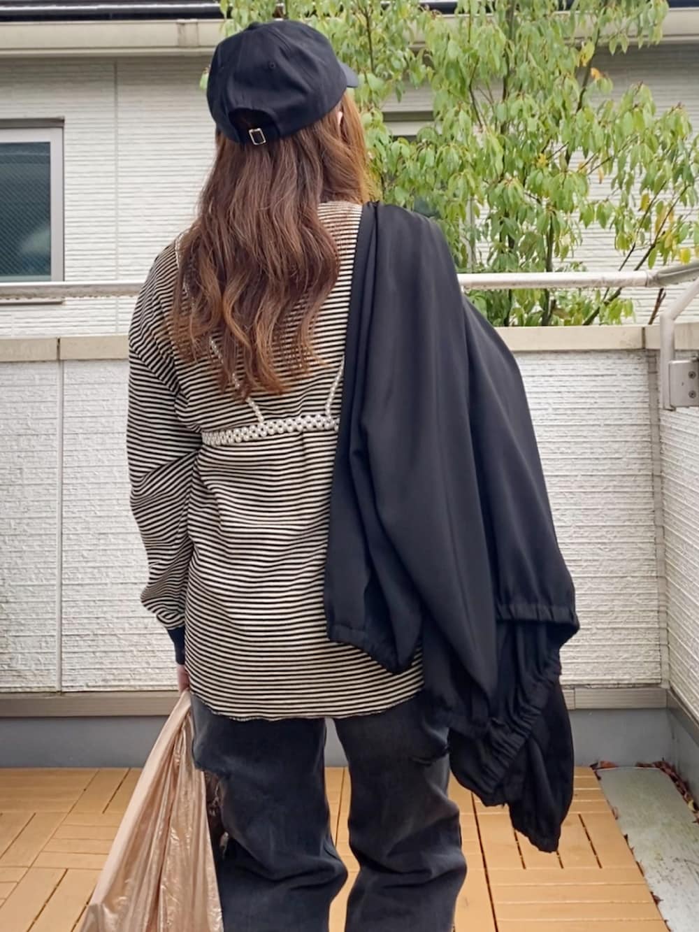 ホワイト系のTシャツ/カットソー、ブラック系のブルゾン、ブラック系のデニムパンツを着用したレディースの春コーディネートの4枚目の写真