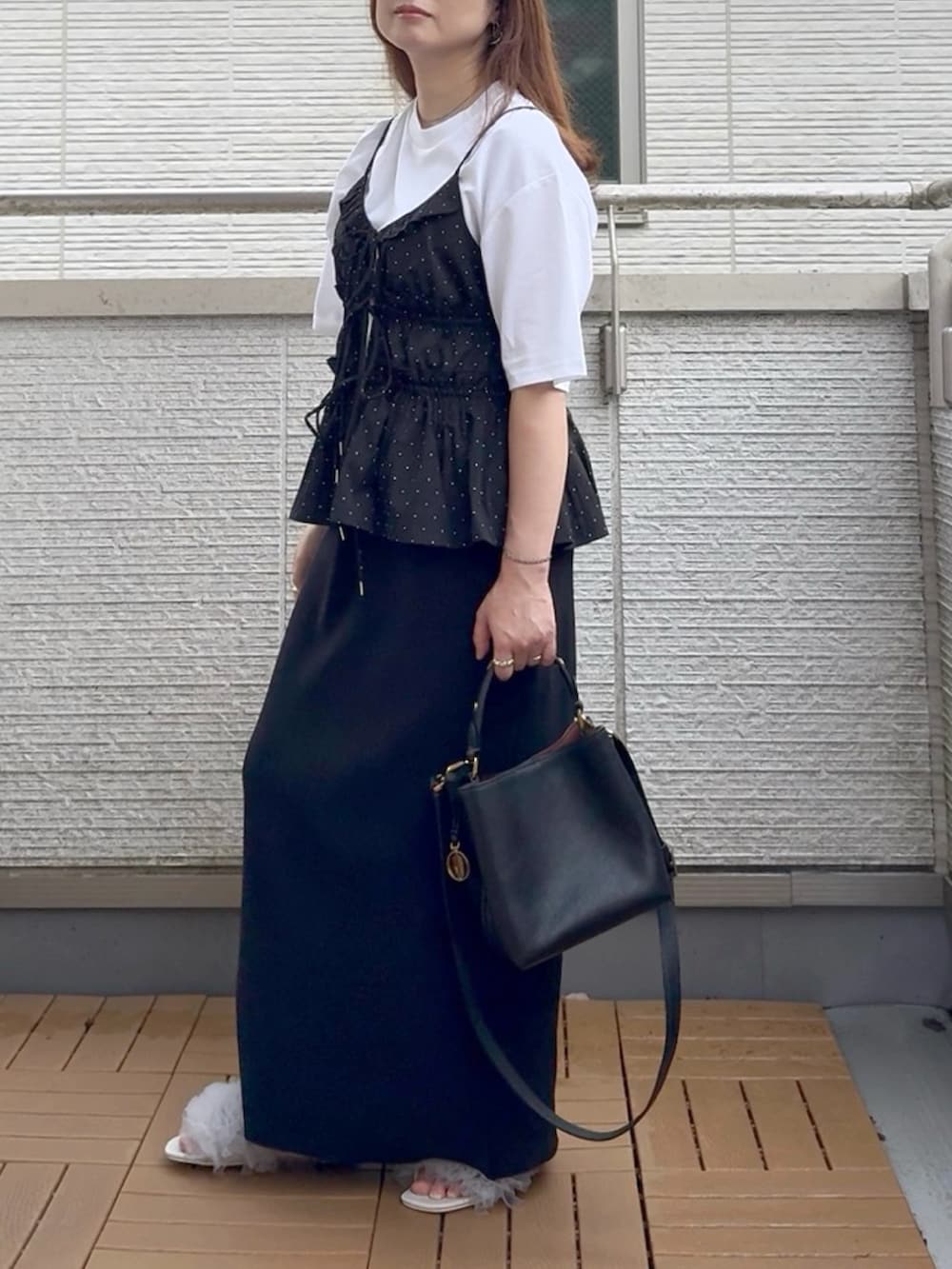 ブラック系のスカート、グレー系のサンダル、ブラック系のキャミソールを着用したレディースの夏コーディネートの2枚目の写真