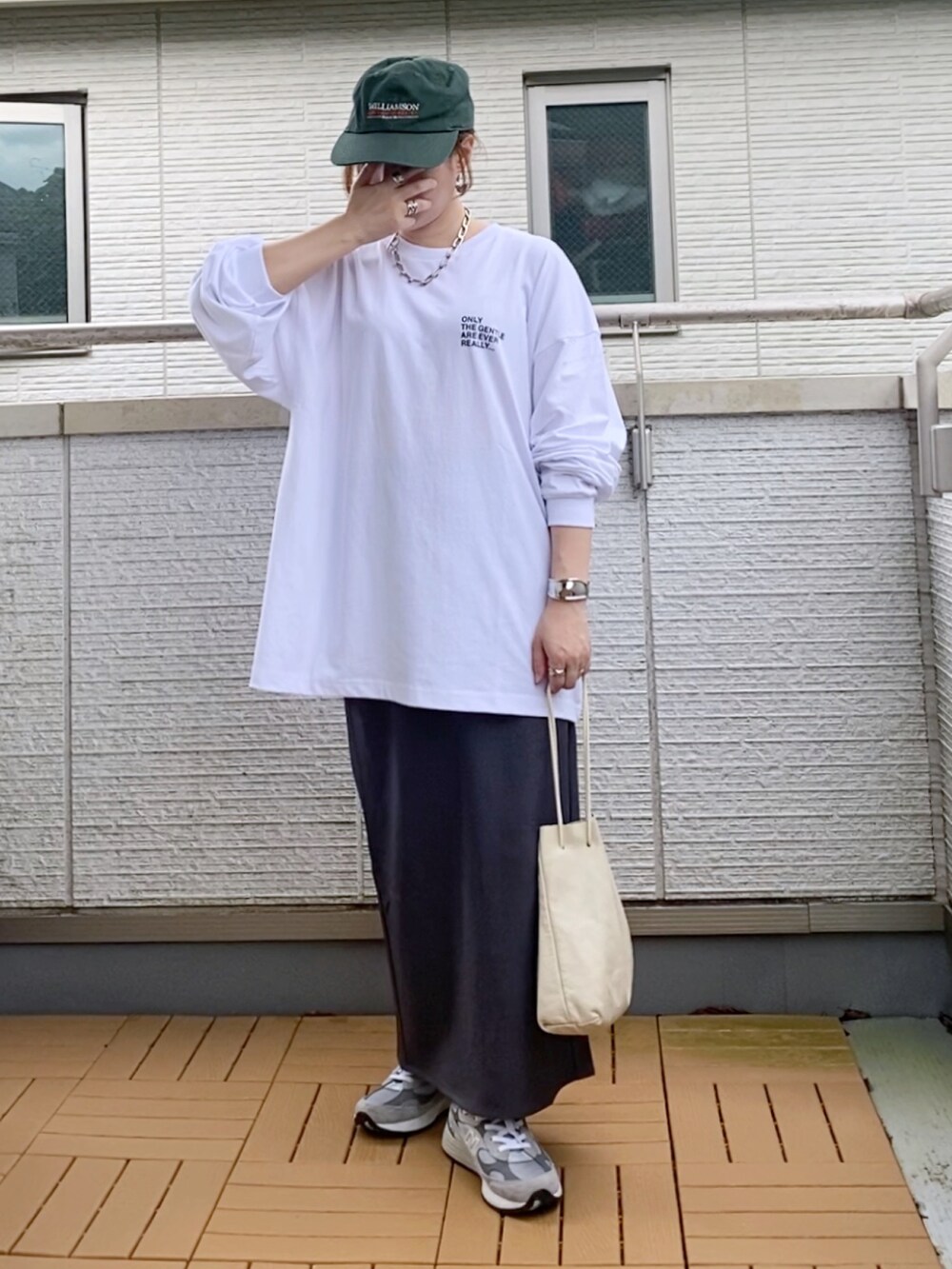 ホワイト系のTシャツ/カットソー、グレー系のスカート、グレー系のスニーカーを着用したレディースの秋コーディネートの3枚目の写真