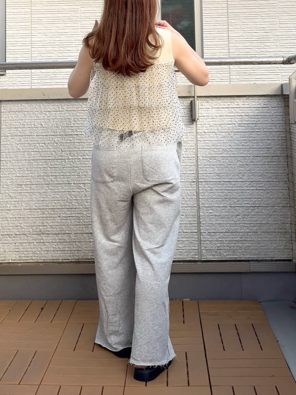 ホワイト系のニット/セーター、グレー系のスウェットパンツ、ブラック系のボディバッグ/ウエストポーチを着用したレディースの夏コーディネートの3枚目の写真