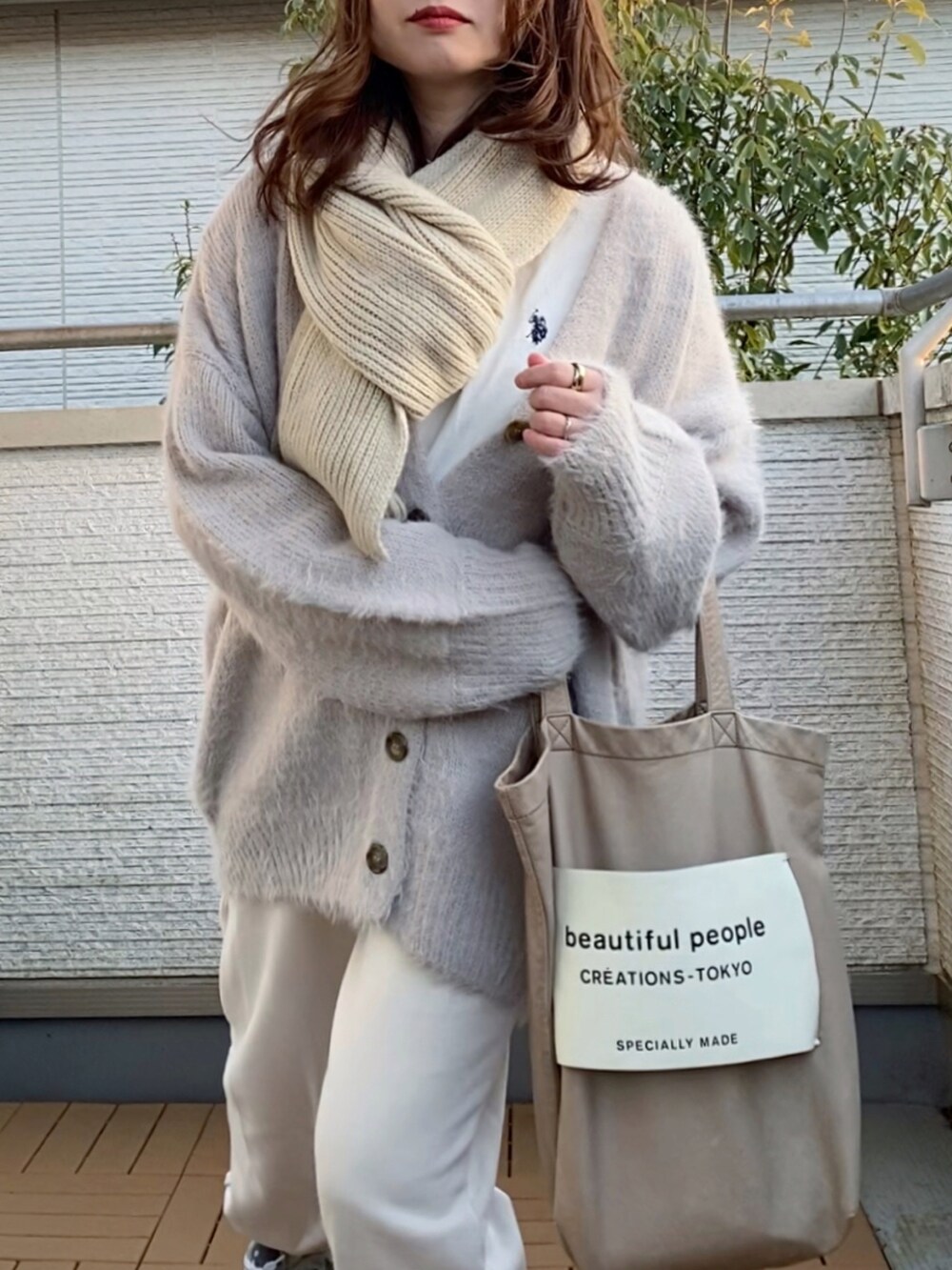 グレー系のカーディガン/ボレロ、ホワイト系のTシャツ/カットソー、ホワイト系のパンツを着用したレディースの冬コーディネートの2枚目の写真