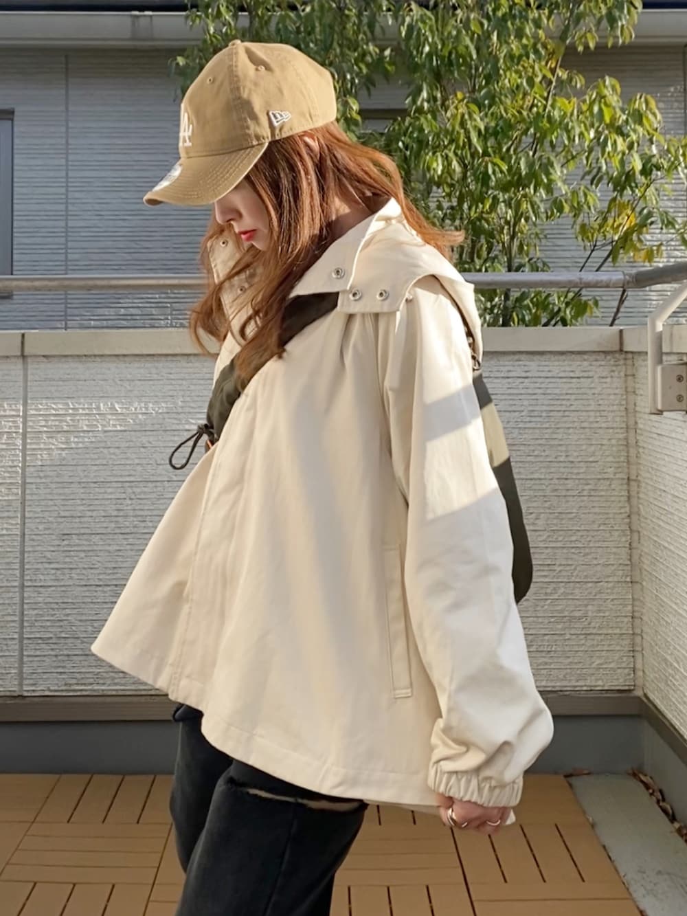 ホワイト系のマウンテンパーカー、ブラック系のTシャツ/カットソー、ブラック系のデニムパンツを着用したレディースの春コーディネートの5枚目の写真