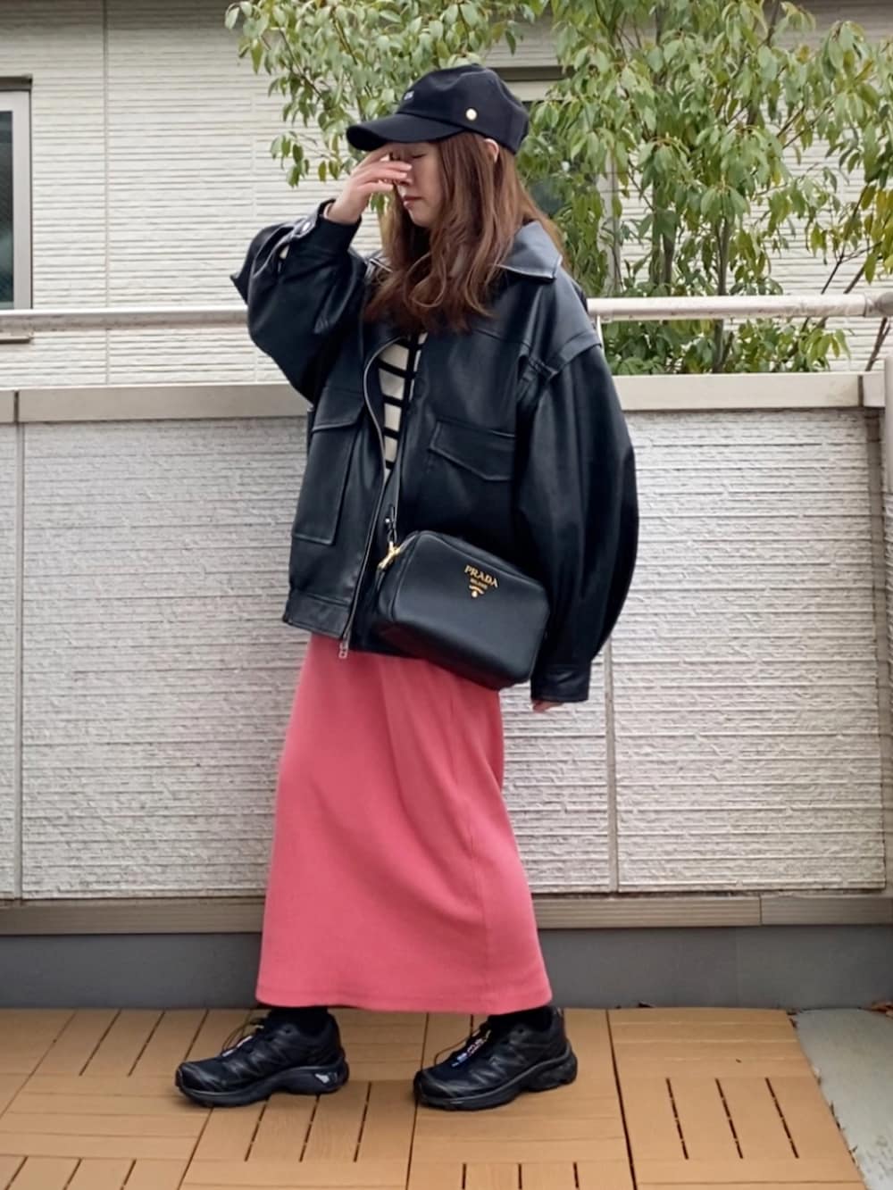 ブラック系のライダースジャケット、ホワイト系のニット/セーター、ピンク系のスカートを着用したレディースの春コーディネートの3枚目の写真