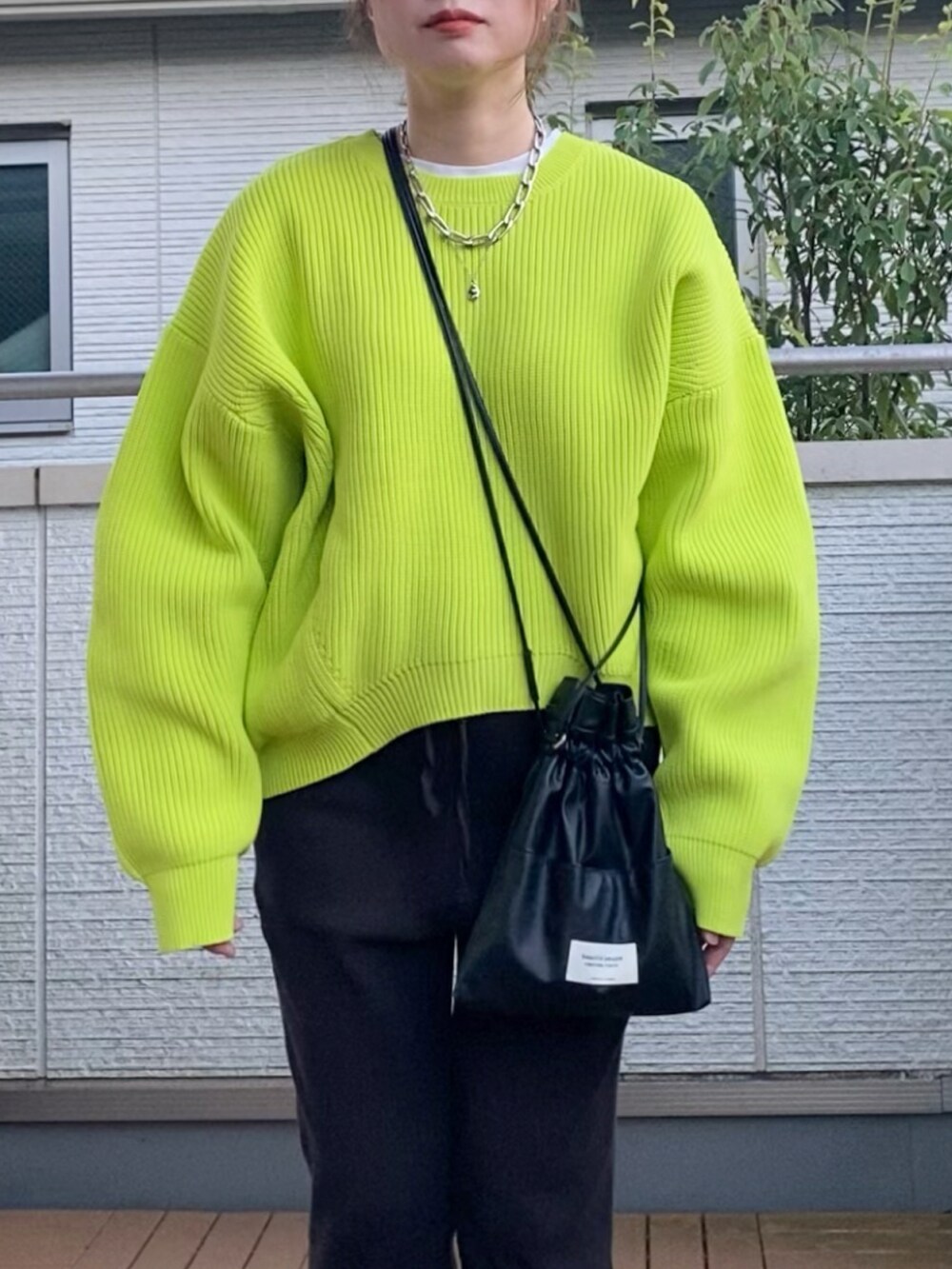 グリーン系のニット/セーター、ブラック系のその他パンツ、ブラック系のショルダーバッグを着用したレディースの秋コーディネートの2枚目の写真