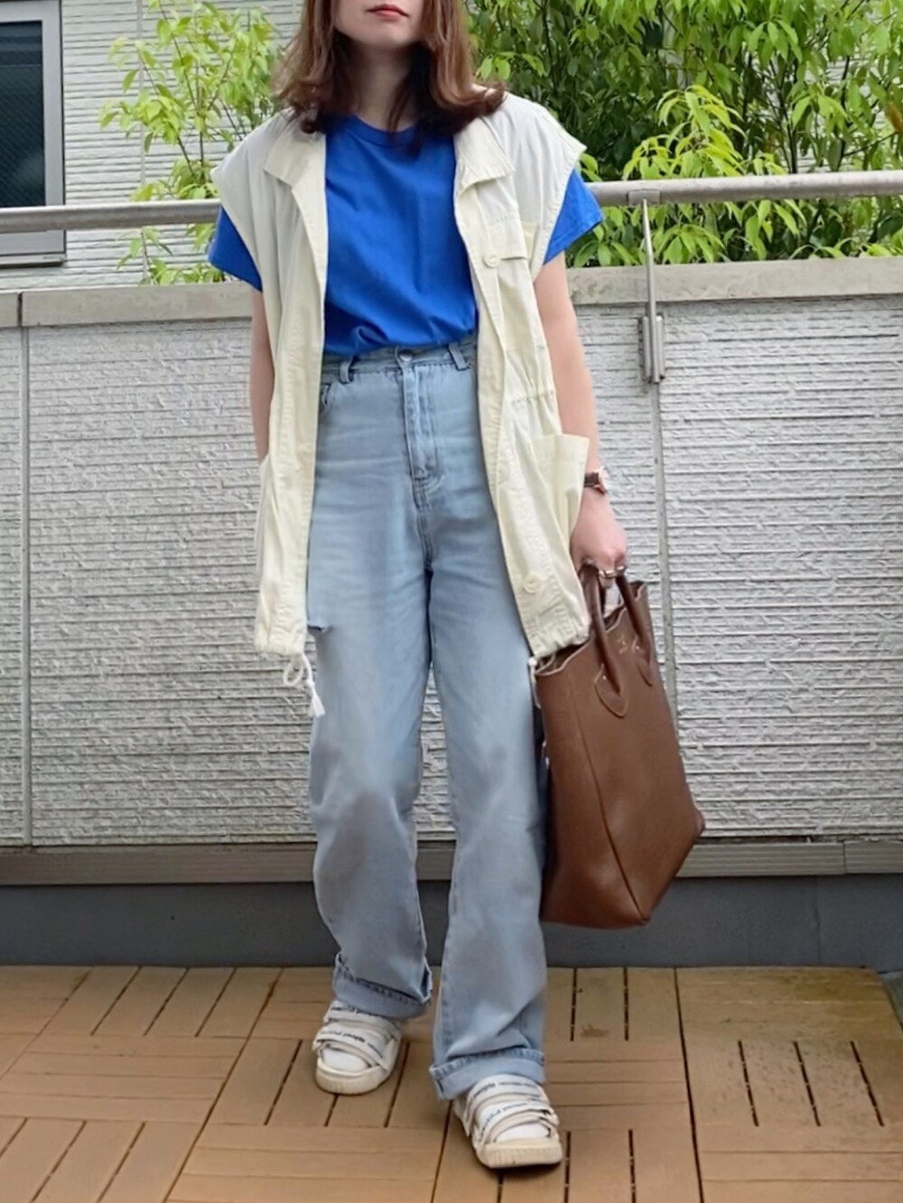 ブルー系のTシャツ/カットソー、ホワイト系のベスト、ブルー系のデニムパンツを着用したレディースの春コーディネートの2枚目の写真