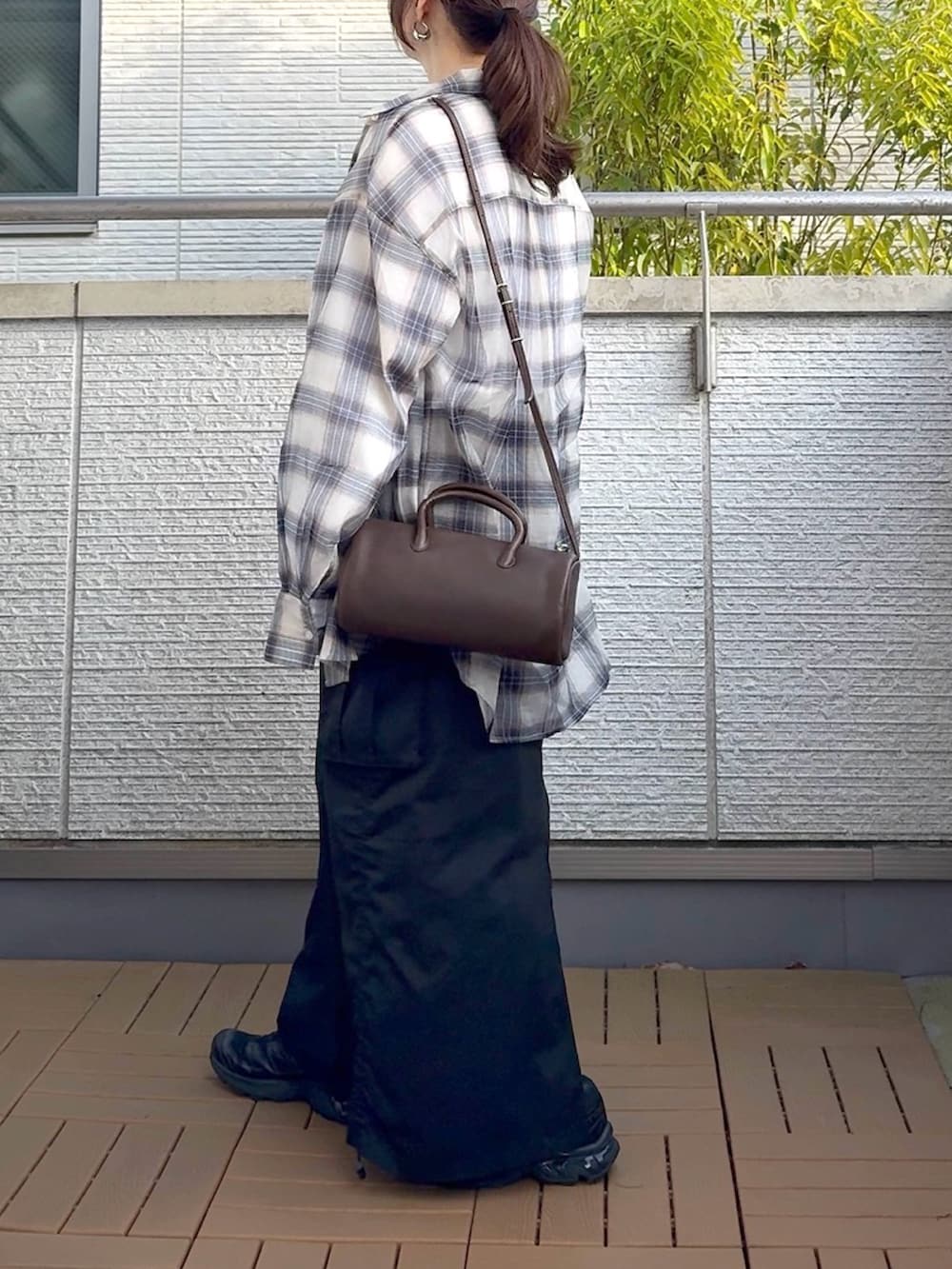 ホワイト系のシャツ/ブラウス、ブラック系のスカート、ブラック系のスニーカーを着用したレディースの春コーディネートの3枚目の写真