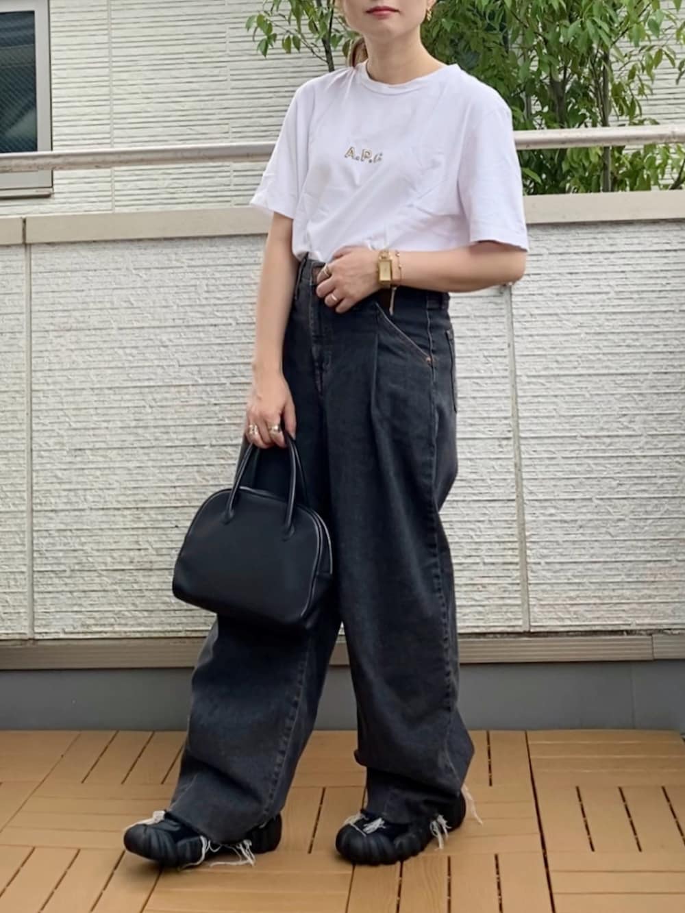 イエロー系のTシャツ/カットソー、ブラック系のデニムパンツ、ブラック系のショルダーバッグを着用したレディースの秋コーディネートの2枚目の写真