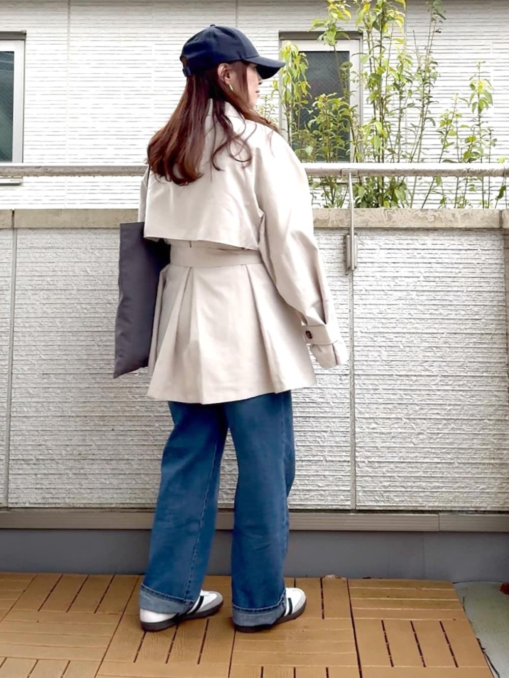 ホワイト系のトレンチコート、ブルー系のデニムパンツ、ホワイト系のスニーカーを着用したレディースの春コーディネートの3枚目の写真