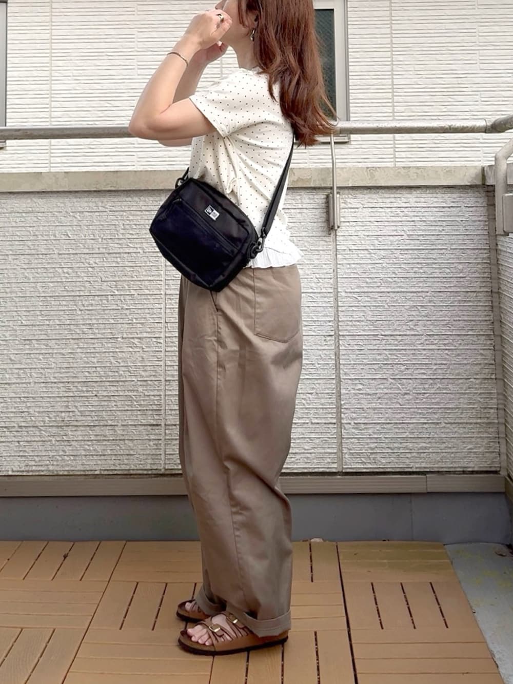 ホワイト系のTシャツ/カットソー、ブラック系のショルダーバッグ、ベージュ系のチノパンツを着用したレディースの夏コーディネートの2枚目の写真