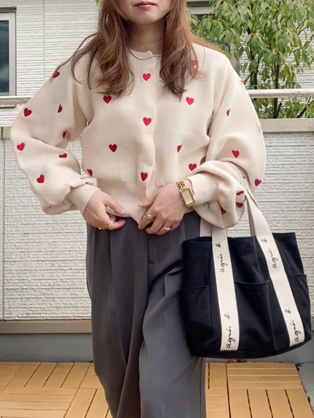 ホワイト系のカーディガン/ボレロ、グレー系のスラックス、ブラック系のトートバッグを着用したレディースの冬コーディネートの3枚目の写真