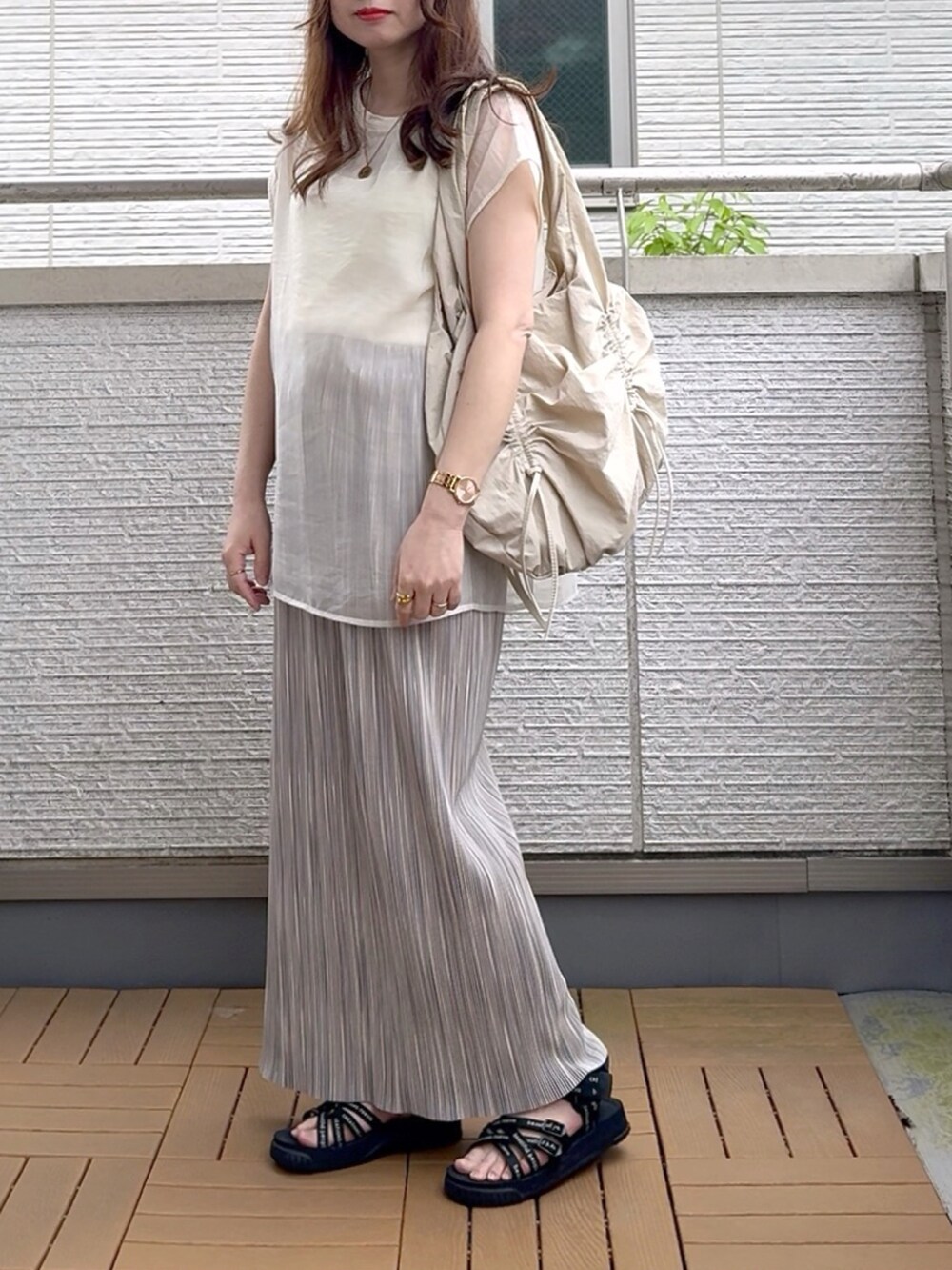 ホワイト系のTシャツ/カットソー、グレー系のスカート、ベージュ系のショルダーバッグを着用したレディースの春コーディネートの2枚目の写真