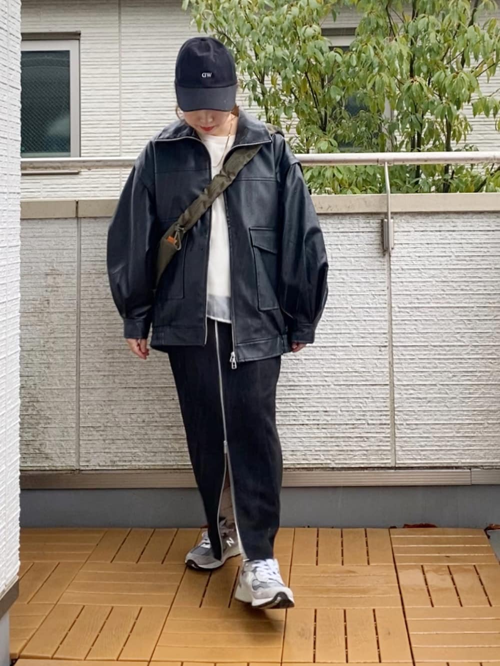 ブラック系のライダースジャケット、ホワイト系のスウェット、ブラック系のスカートを着用したレディースの春コーディネートの4枚目の写真