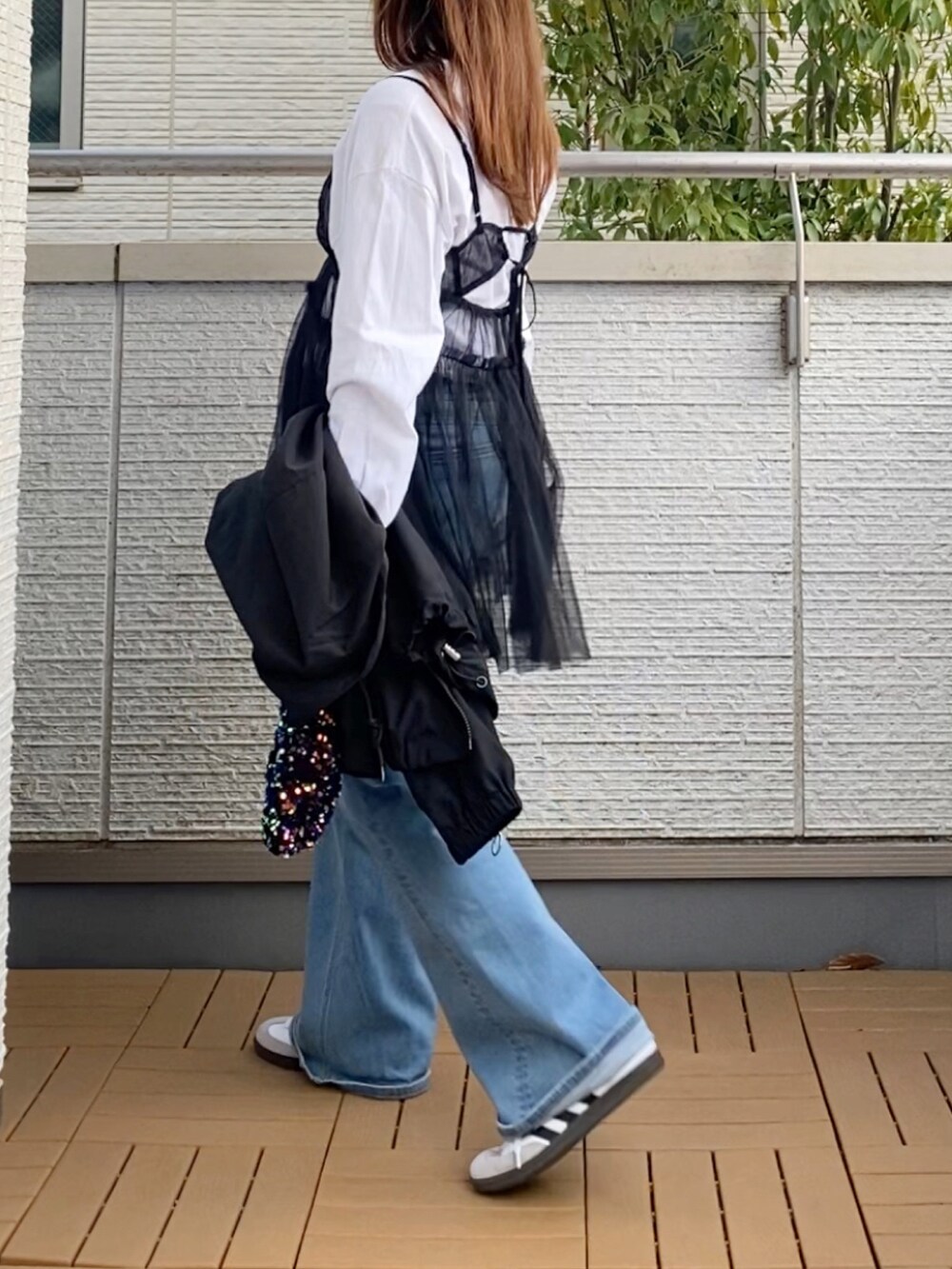 ブラック系のキャミソール、ホワイト系のTシャツ/カットソー、ブラック系のナイロンジャケットを着用したレディースの春コーディネートの2枚目の写真