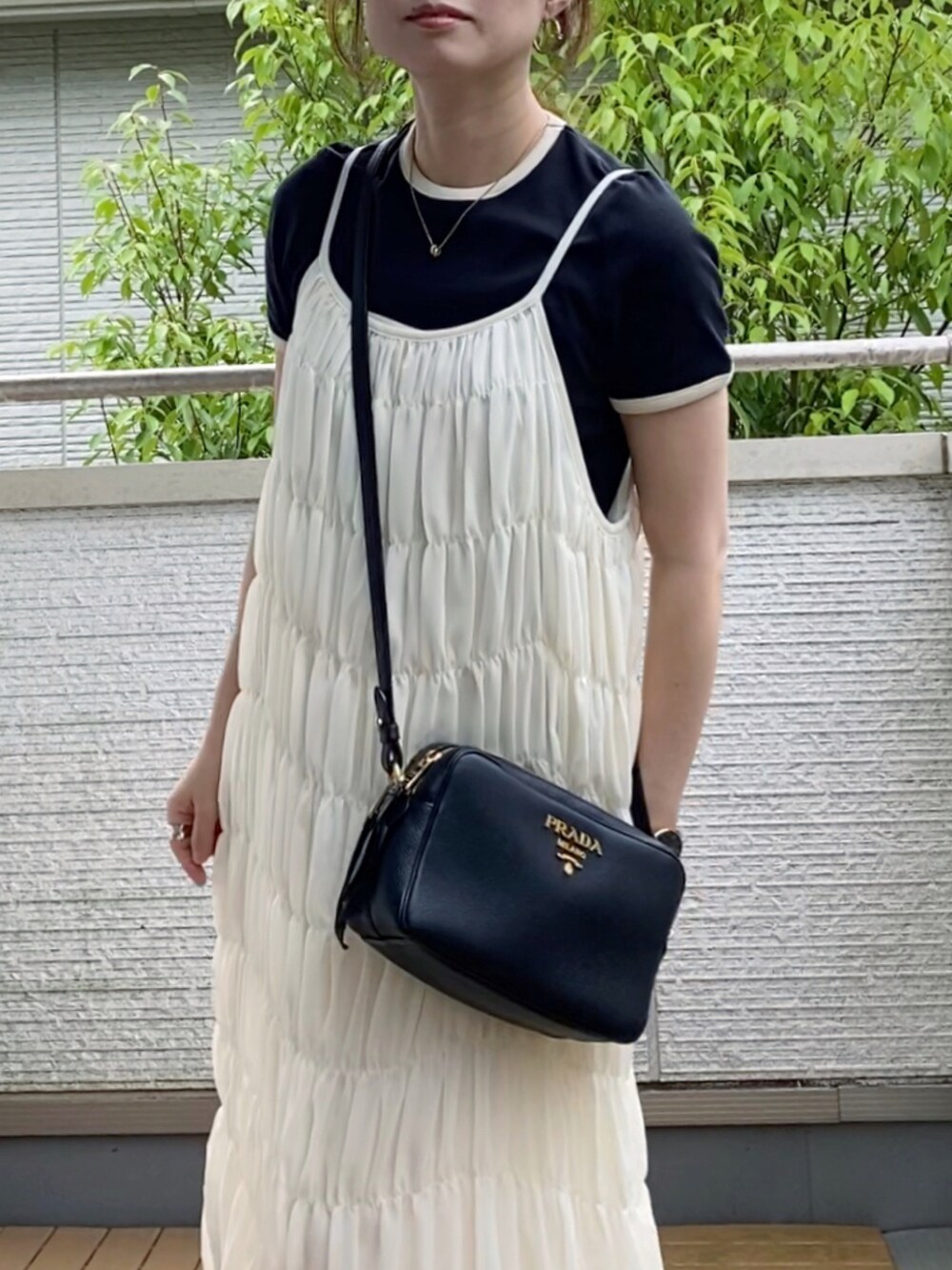 ホワイト系のワンピース、ブラック系のTシャツ/カットソー、ホワイト系のサンダルを着用したレディースの夏コーディネートの4枚目の写真