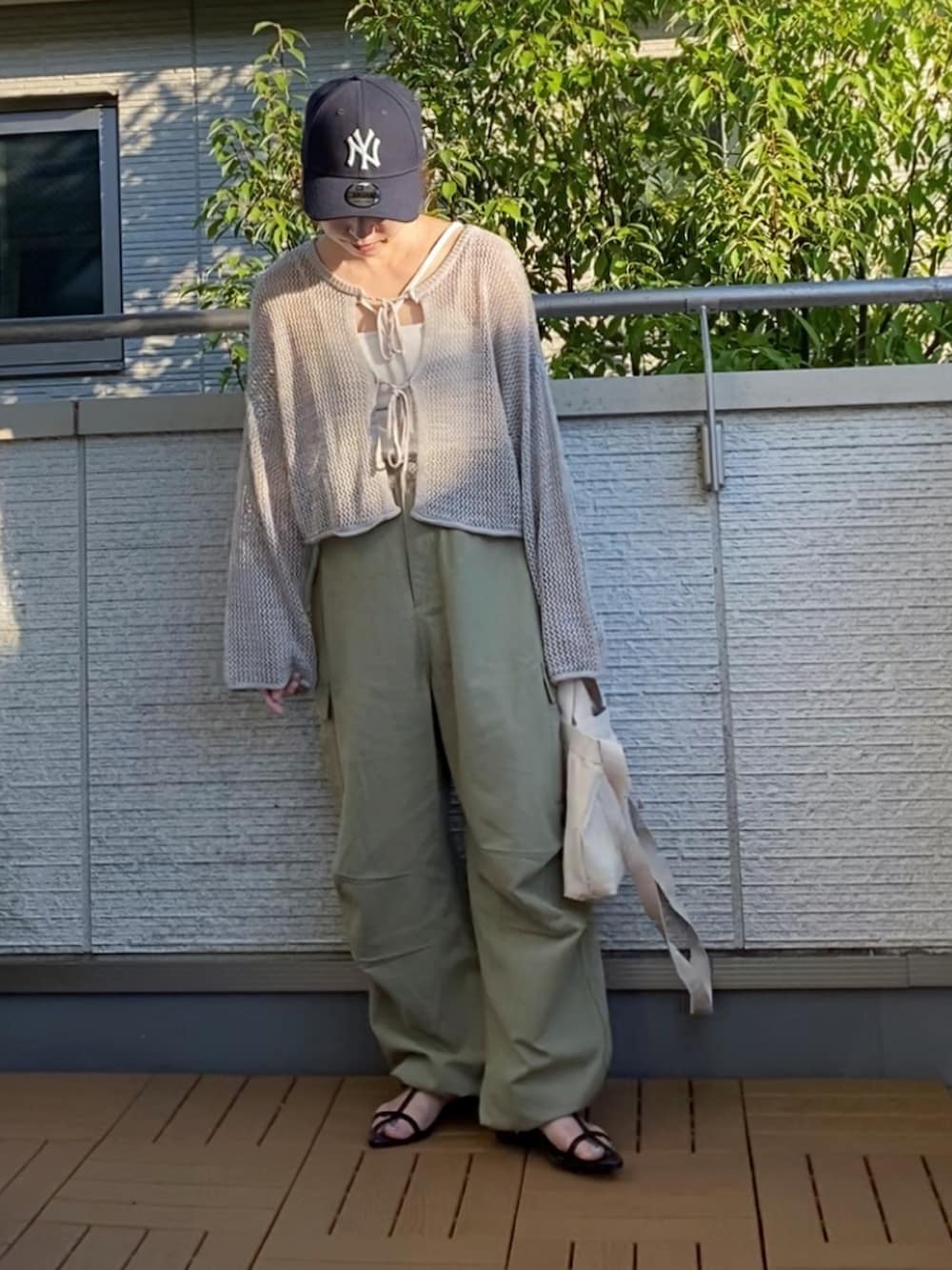 グレー系のカーディガン/ボレロ、ホワイト系のキャミソール、ベージュ系のカーゴパンツを着用したレディースの夏コーディネートの2枚目の写真