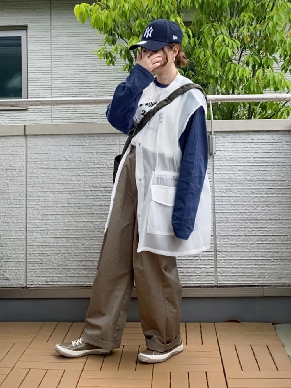 ホワイト系のTシャツ/カットソー、ホワイト系のベスト、ベージュ系のチノパンツを着用したレディースの春コーディネートの2枚目の写真