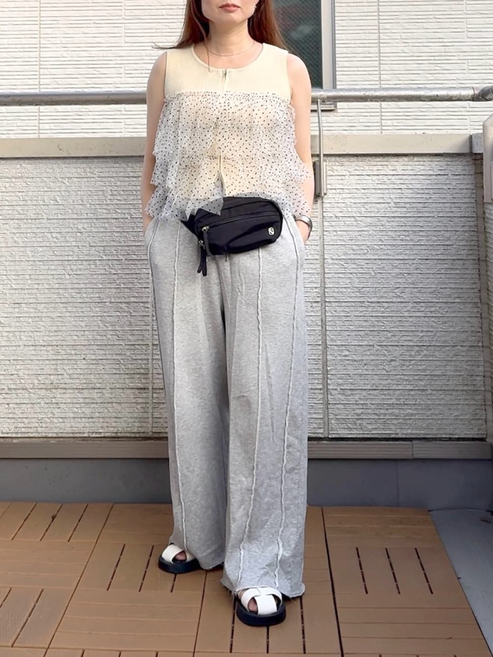 ホワイト系のニット/セーター、グレー系のスウェットパンツ、ブラック系のボディバッグ/ウエストポーチを着用したレディースの夏コーディネートの2枚目の写真