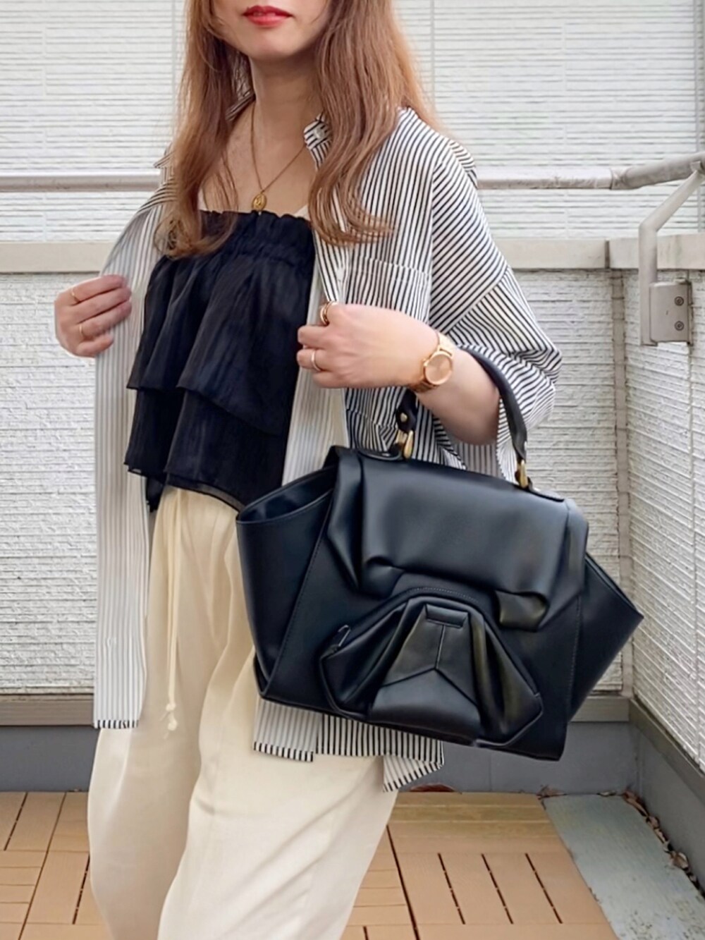 ブラック系のハンドバッグ、ブラック系のキャミソール、その他のシャツ/ブラウスを着用したレディースの夏コーディネートの4枚目の写真