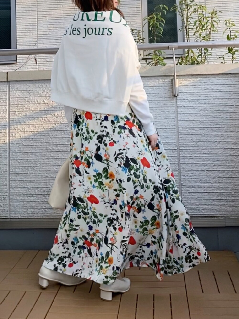 ホワイト系のTシャツ/カットソー、ホワイト系のスカート、ホワイト系のハンドバッグを着用したレディースの春コーディネートの2枚目の写真