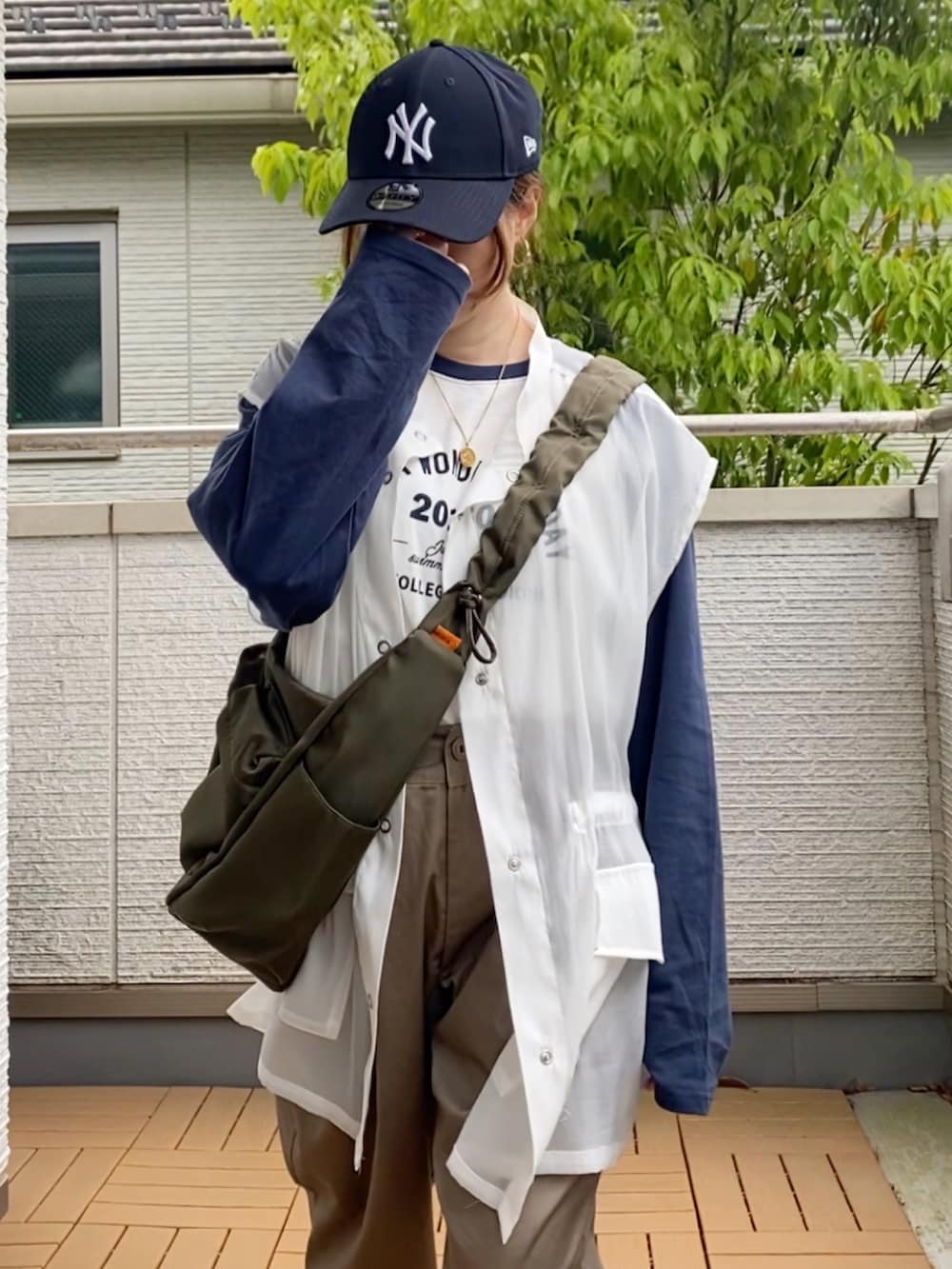 ホワイト系のTシャツ/カットソー、ホワイト系のベスト、ベージュ系のチノパンツを着用したレディースの春コーディネートの5枚目の写真