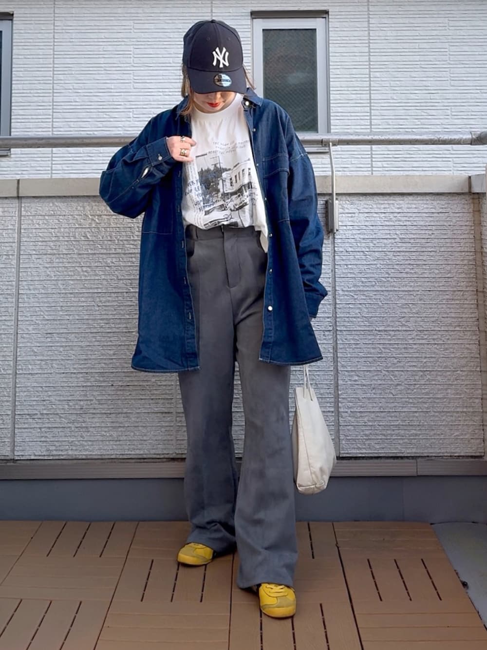 ブルー系のシャツ/ブラウス、ホワイト系のTシャツ/カットソー、グレー系のスラックスを着用したレディースの春コーディネートの2枚目の写真